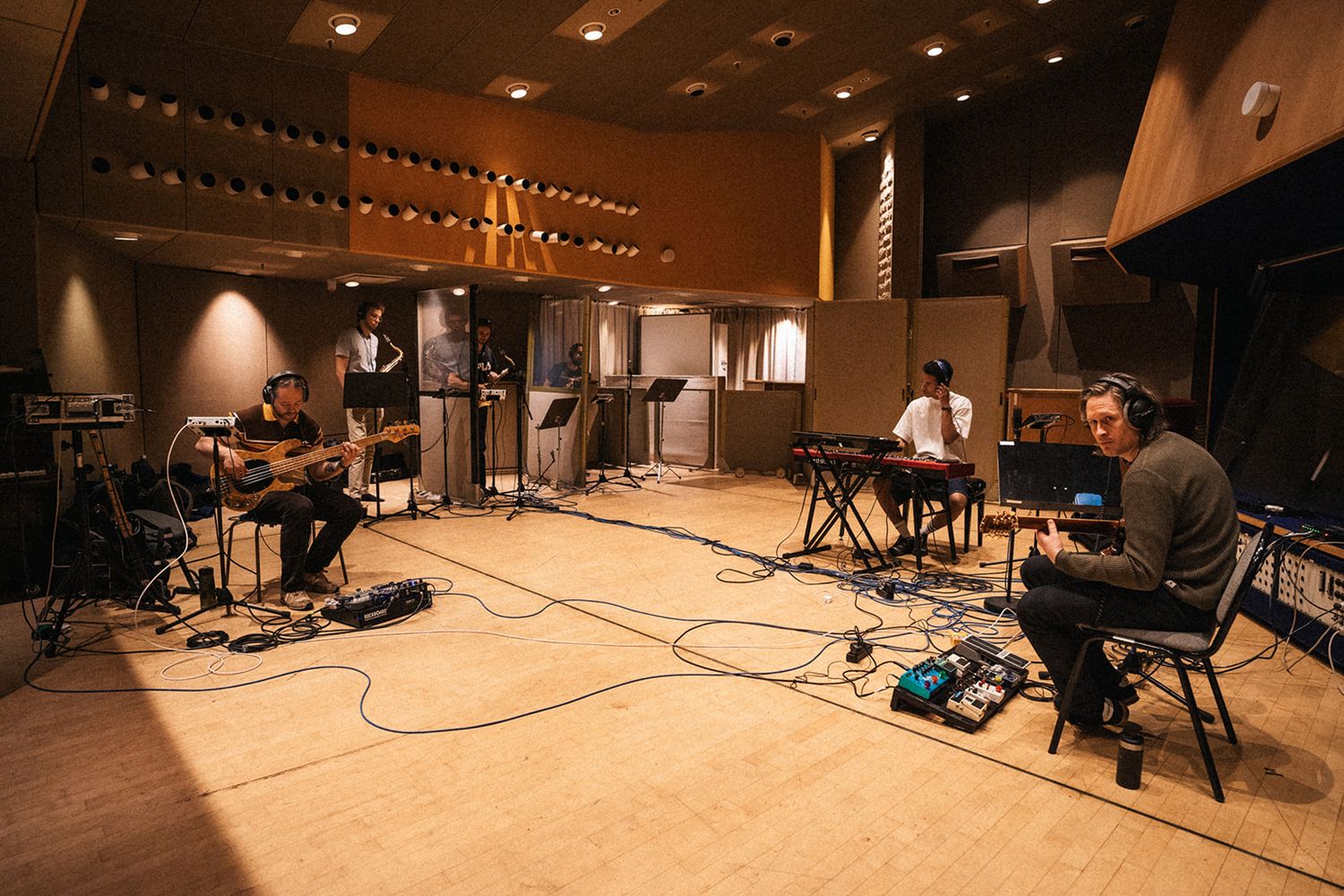 Professional recording studio setup with various instruments and equipment arranged in a warm-lit space.