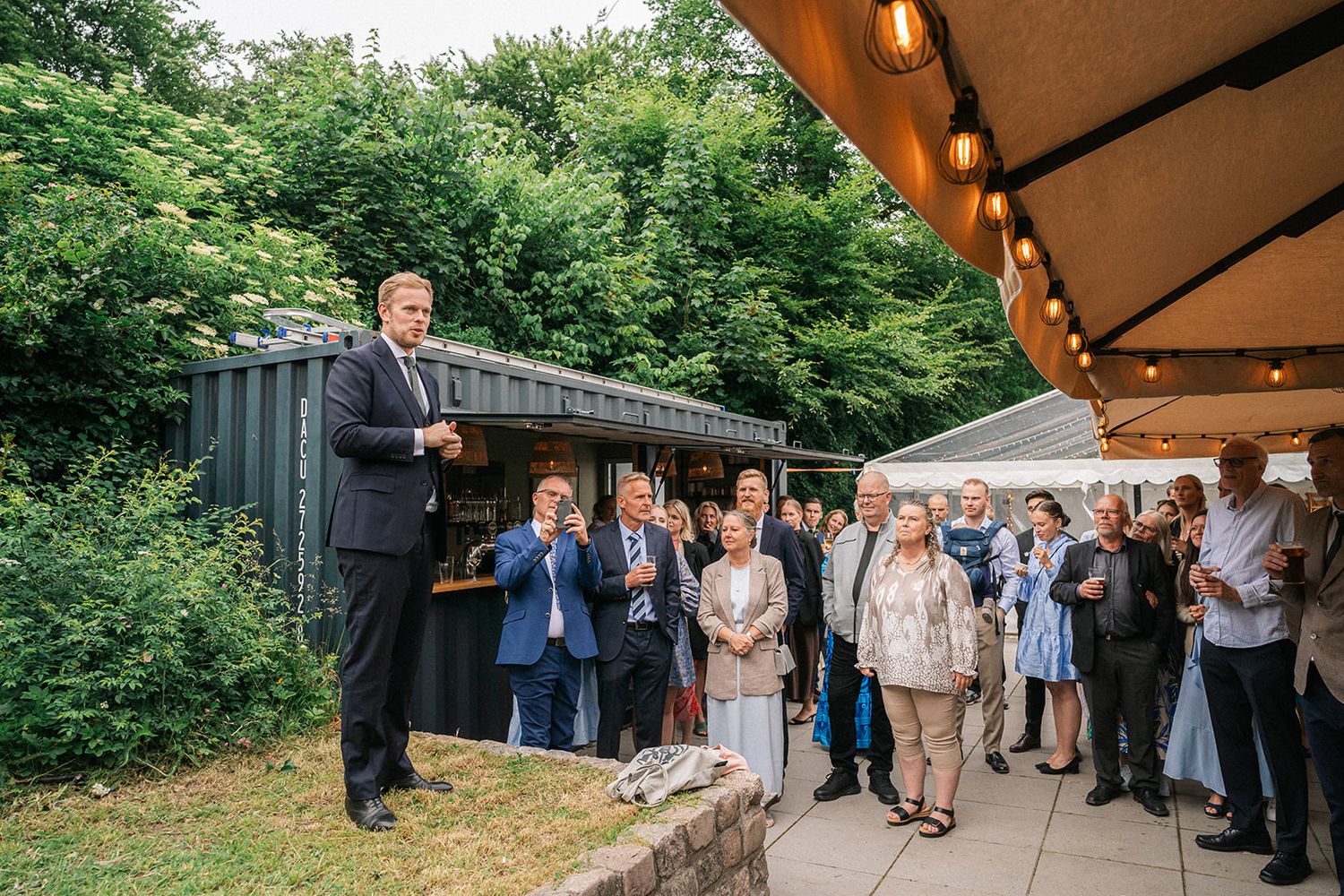 Wedding guests dance and celebrate together under a covered outdoor venue during an evening reception.