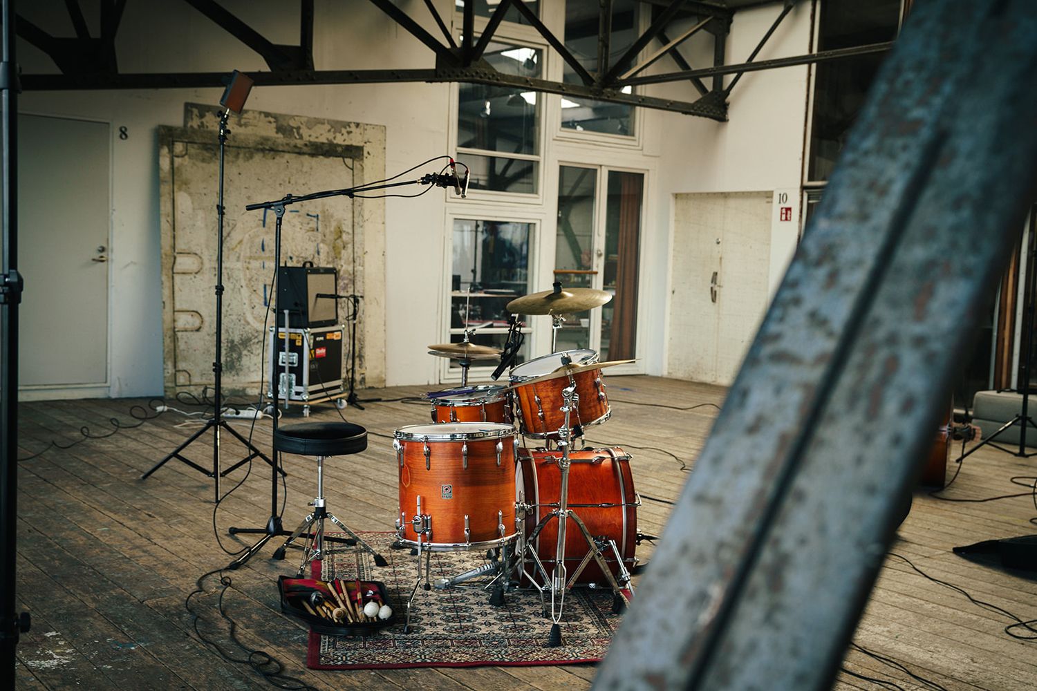 Professional photography studio interior showing lighting equipment, stands, and industrial space setup.