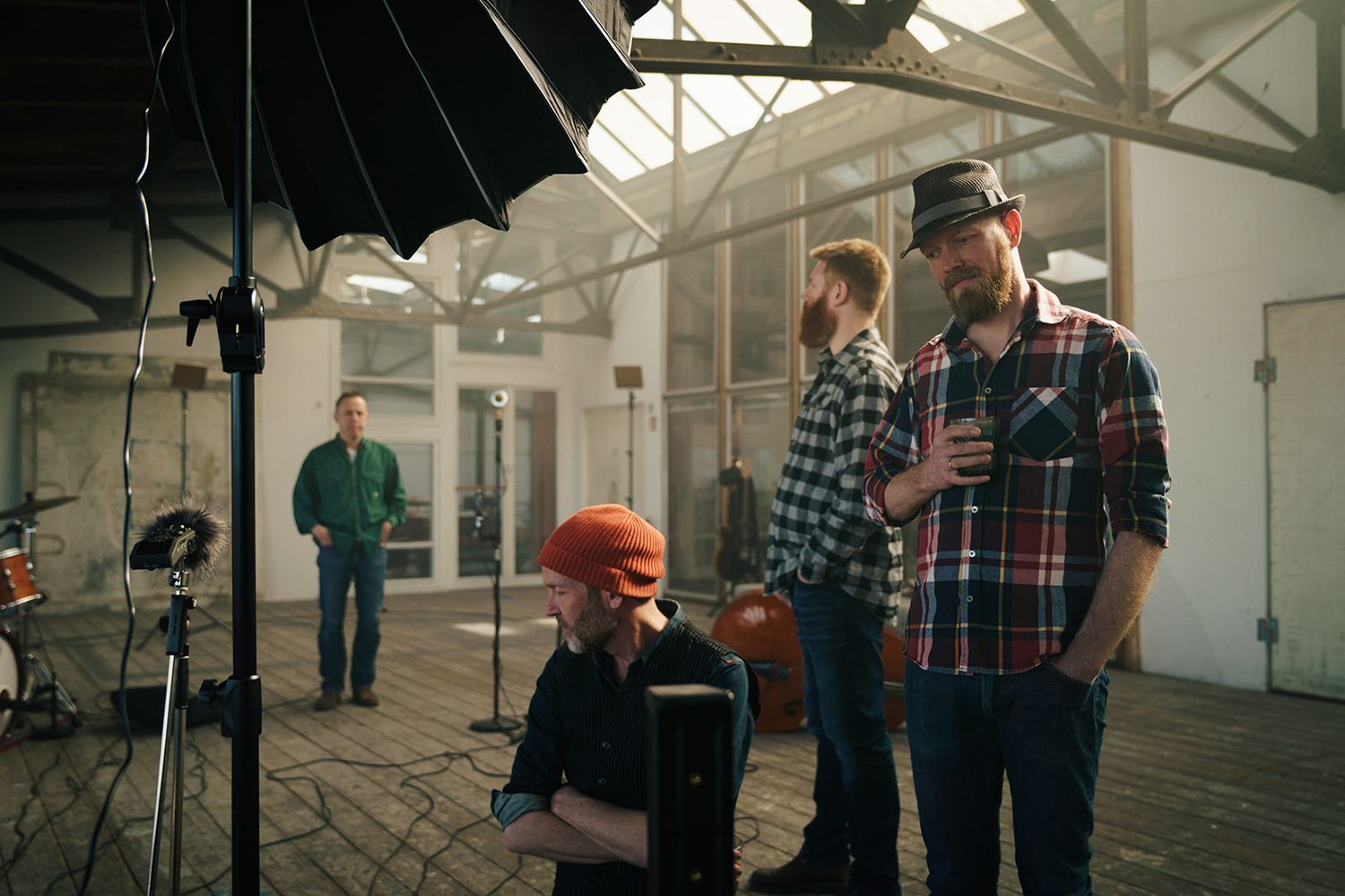 Four sequential photos showing people walking through an industrial space with white walls and natural lighting.