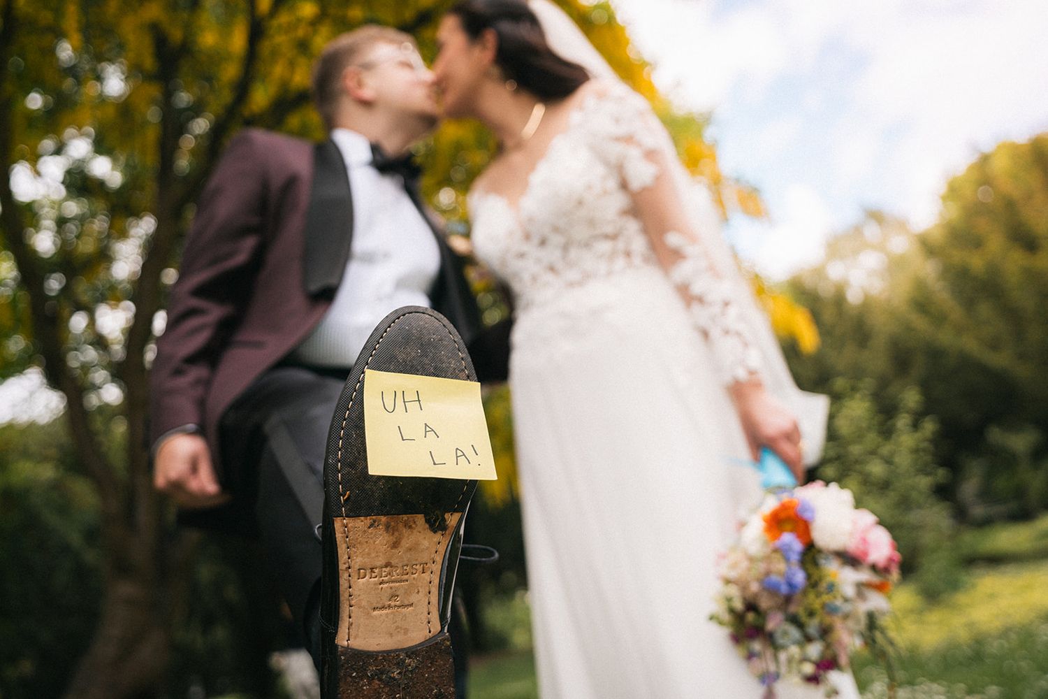 Wedding couple poses in a beautiful autumn garden with golden sunlight filtering through.