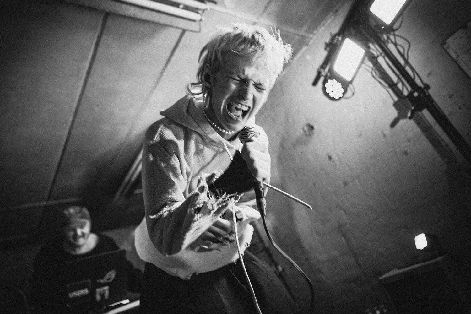 Black and white photos of musicians performing passionately on stage at an underground concert venue.
