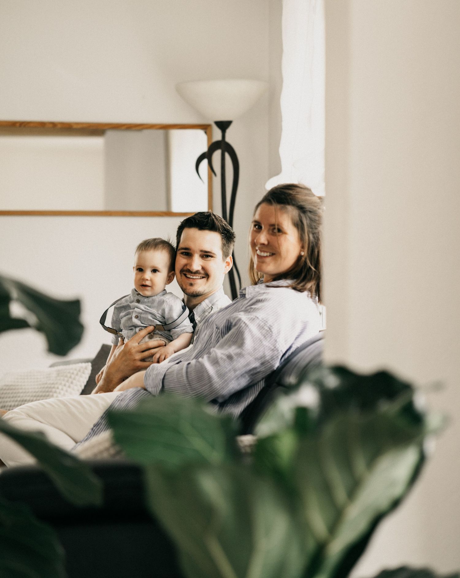 People relaxing together on a white couch while sharing a lighthearted moment in a bright, modern living space.