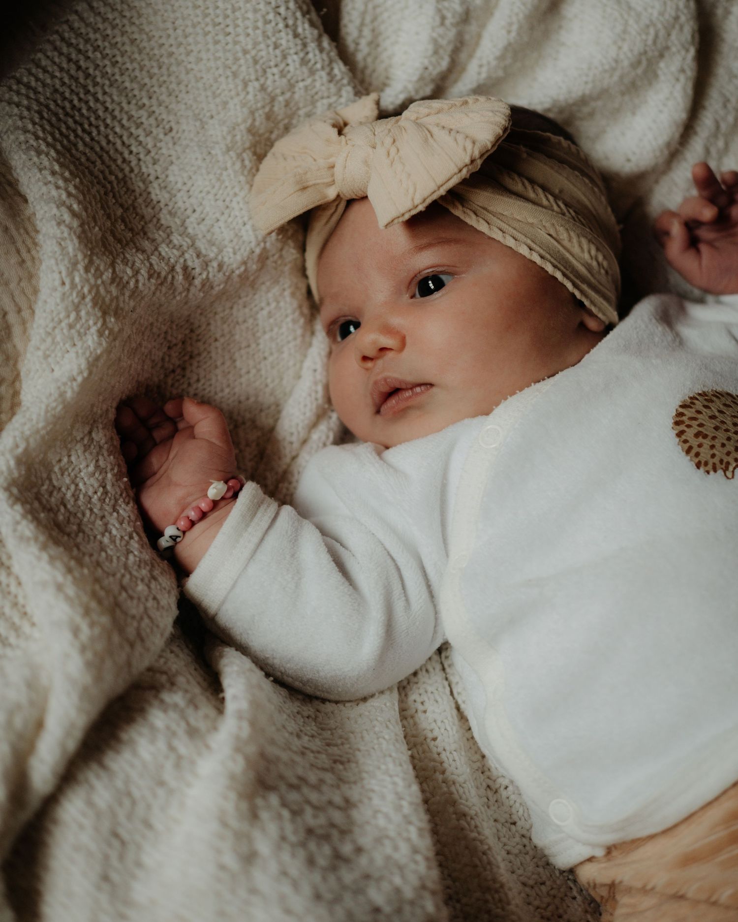 A cozy close-up photo series of a baby wrapped in soft gray blankets while resting.