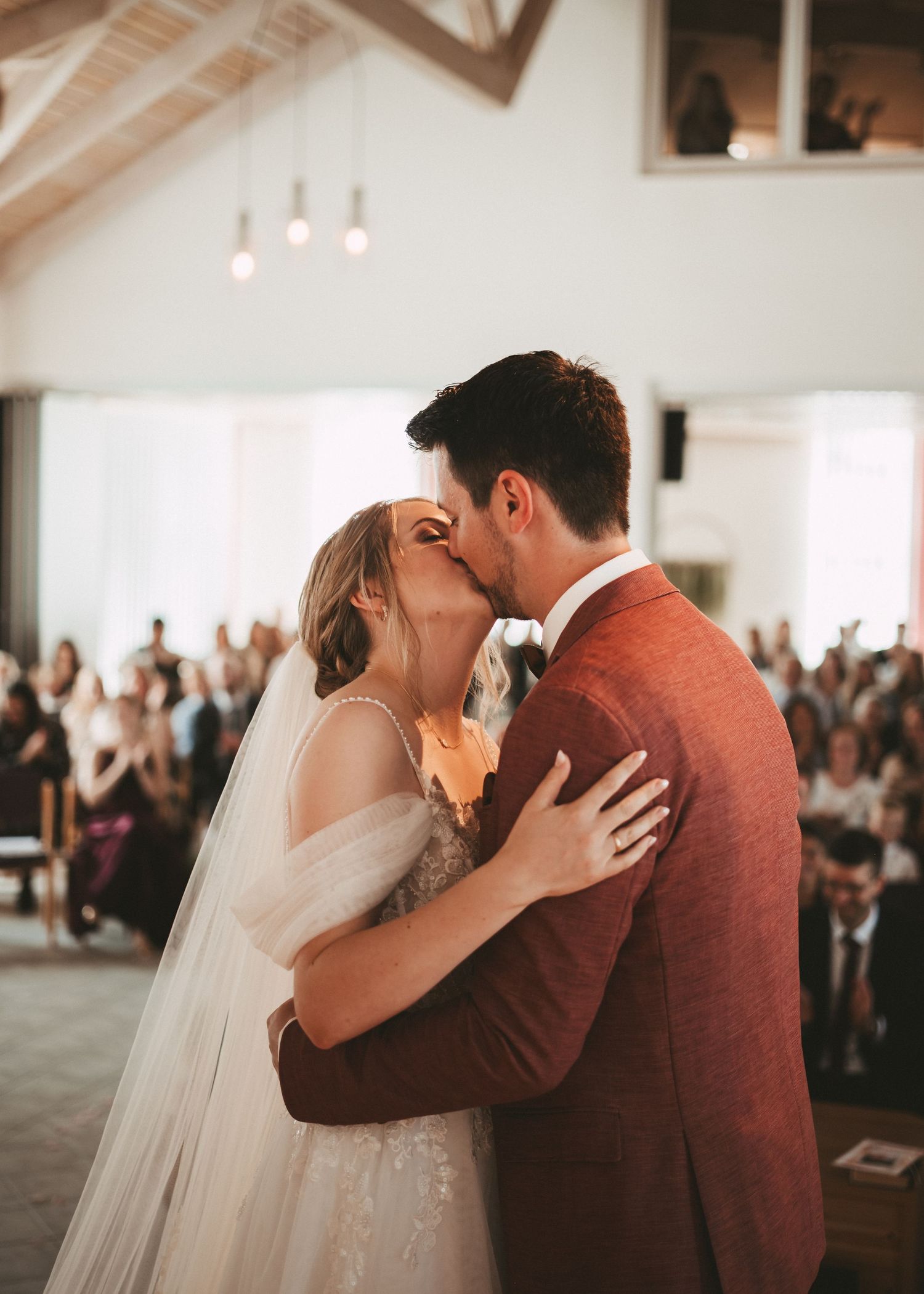 Intimate wedding ceremony moments captured in a bright indoor venue with burgundy accents.