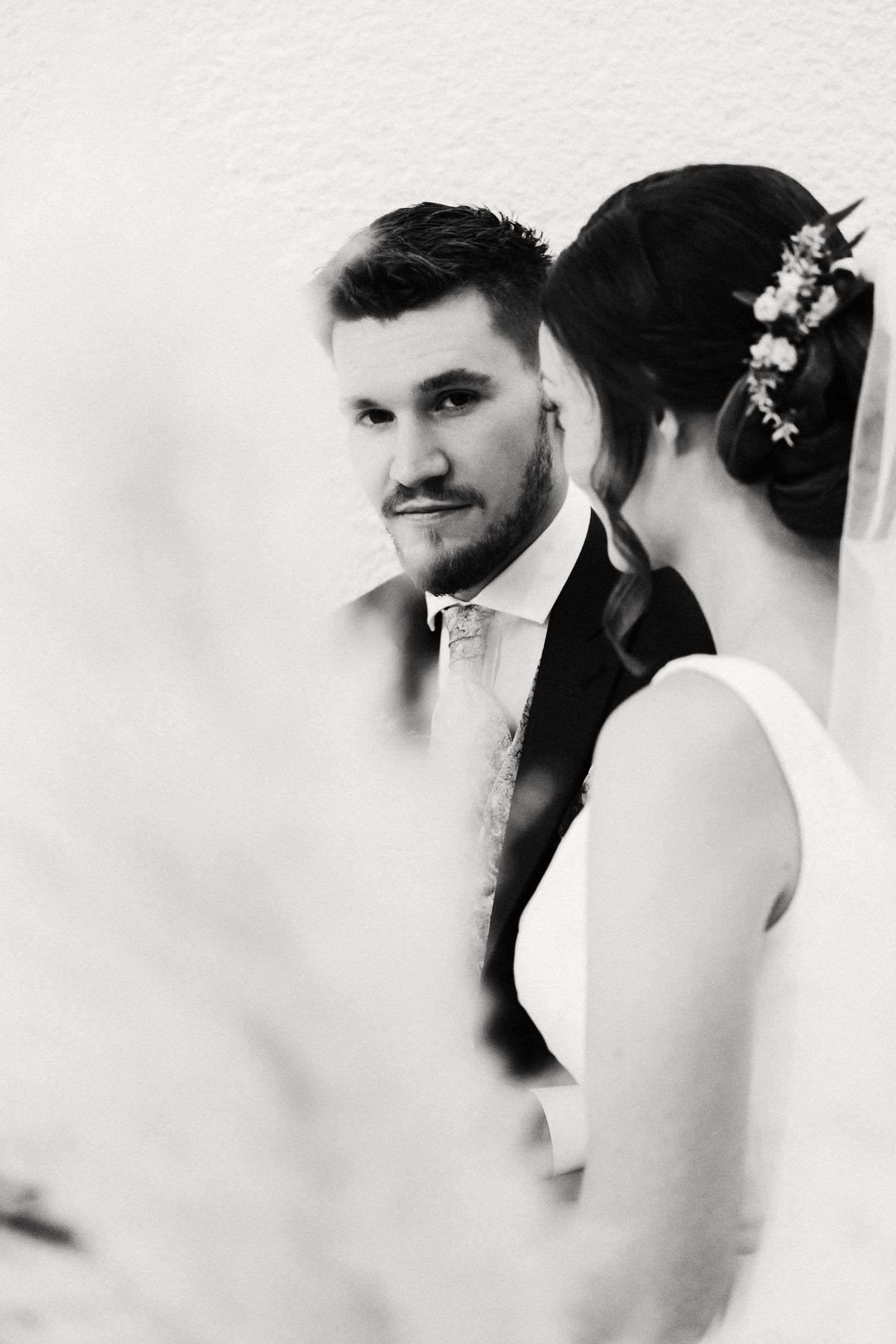 A romantic black and white wedding photo series showing intimate close-up moments between the bride and groom.