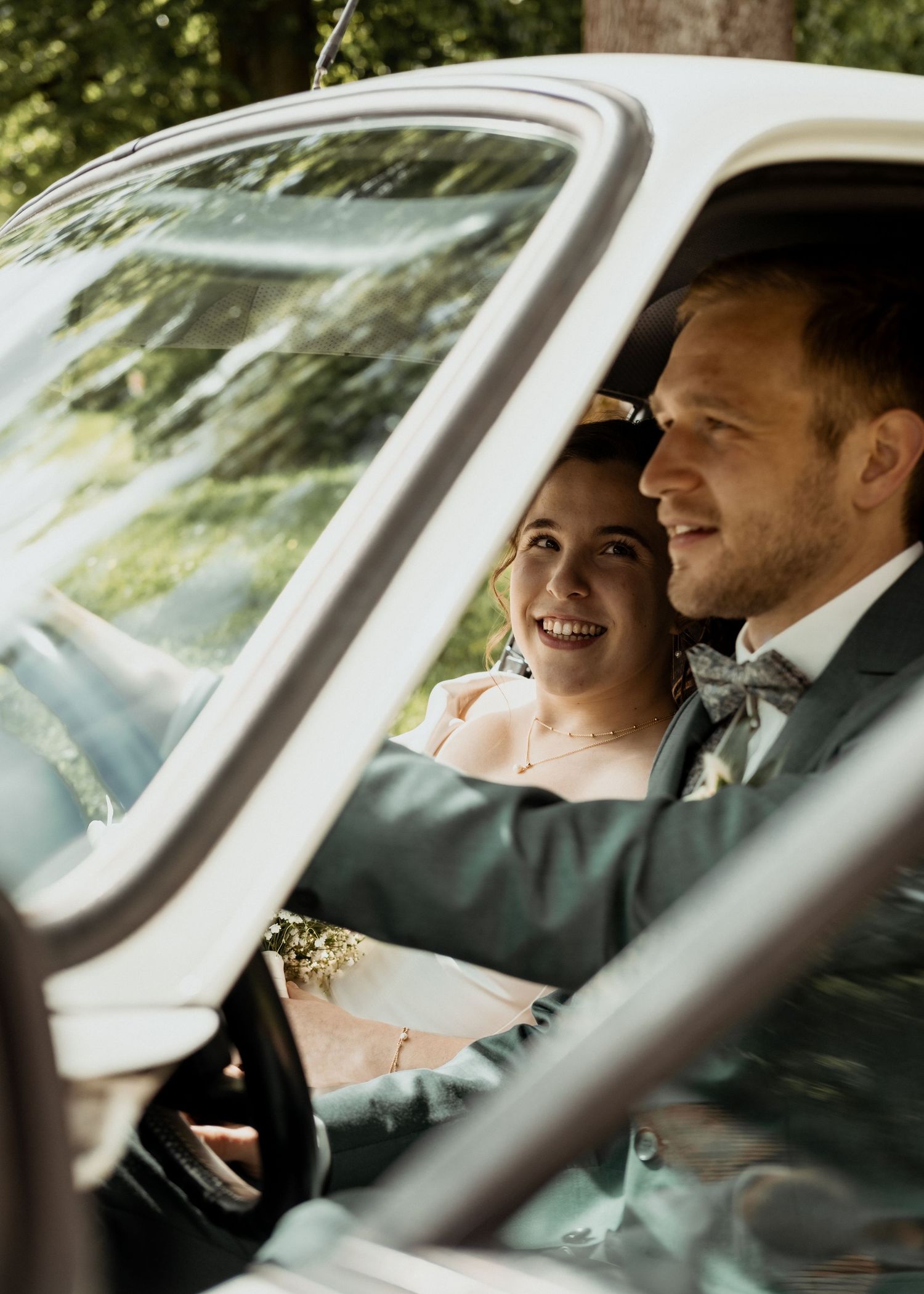A couple shares laughter while sitting in a car, viewed through multiple side-by-side frames.