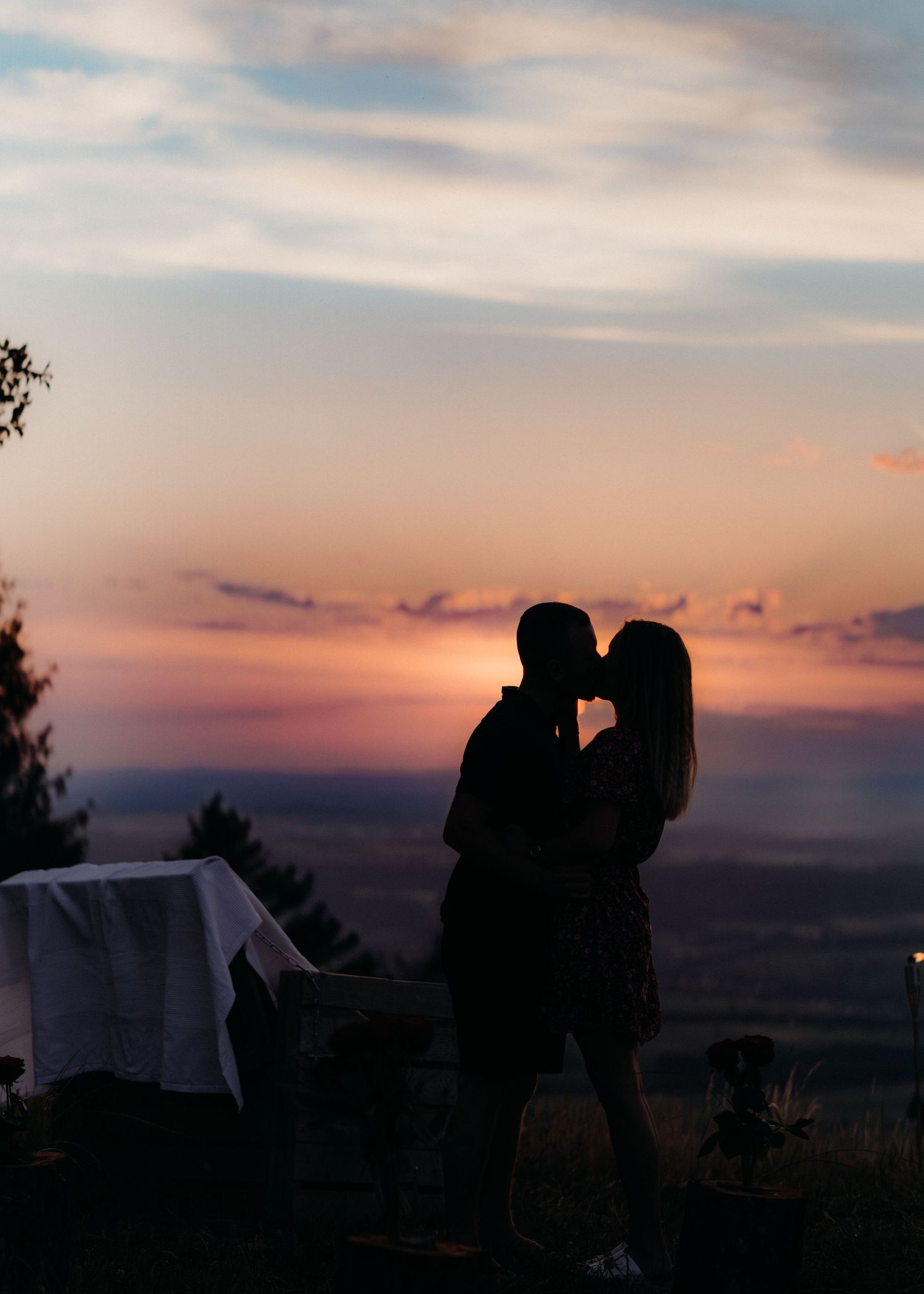 A silhouetted couple shares a romantic moment against a colorful sunset sky in multiple sequential photos.
