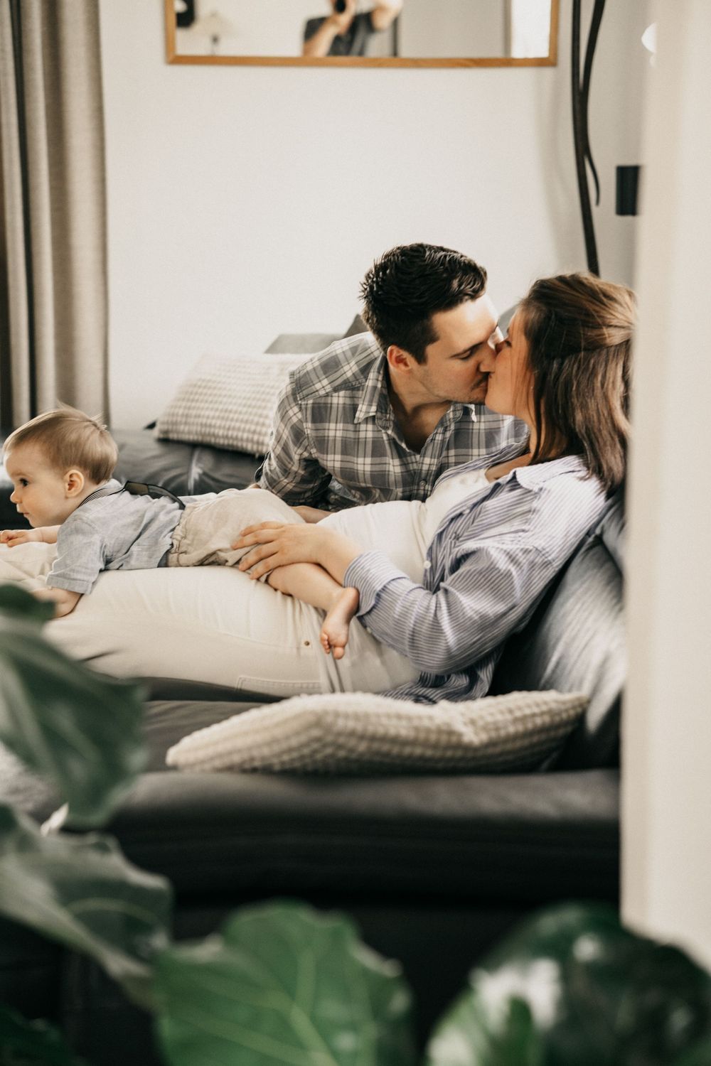 Couple relaxing together on a cozy gray couch with throw pillows in a modern living room.