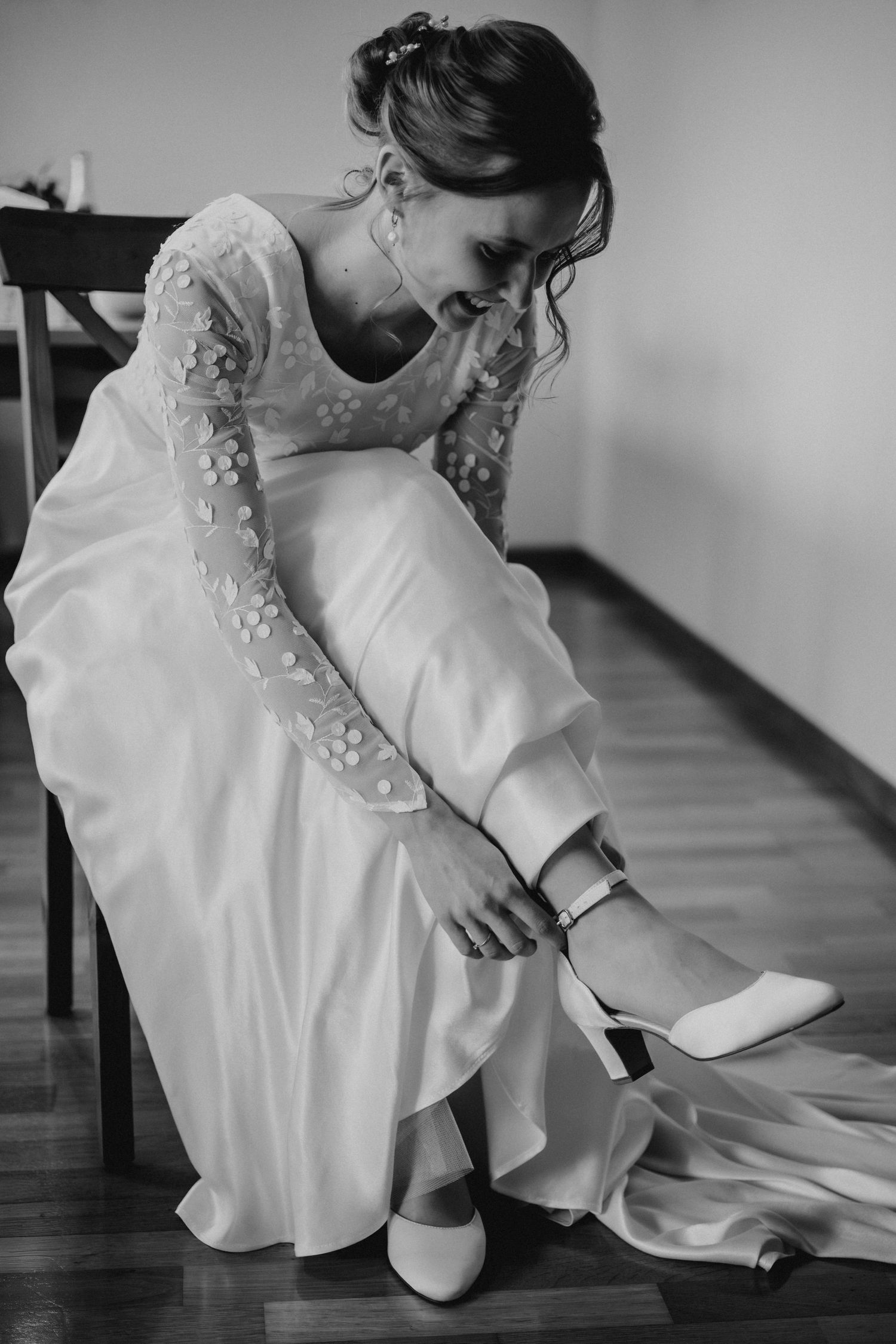 A bride in a white dress adjusts her shoe while sitting in a series of black and white photos.
