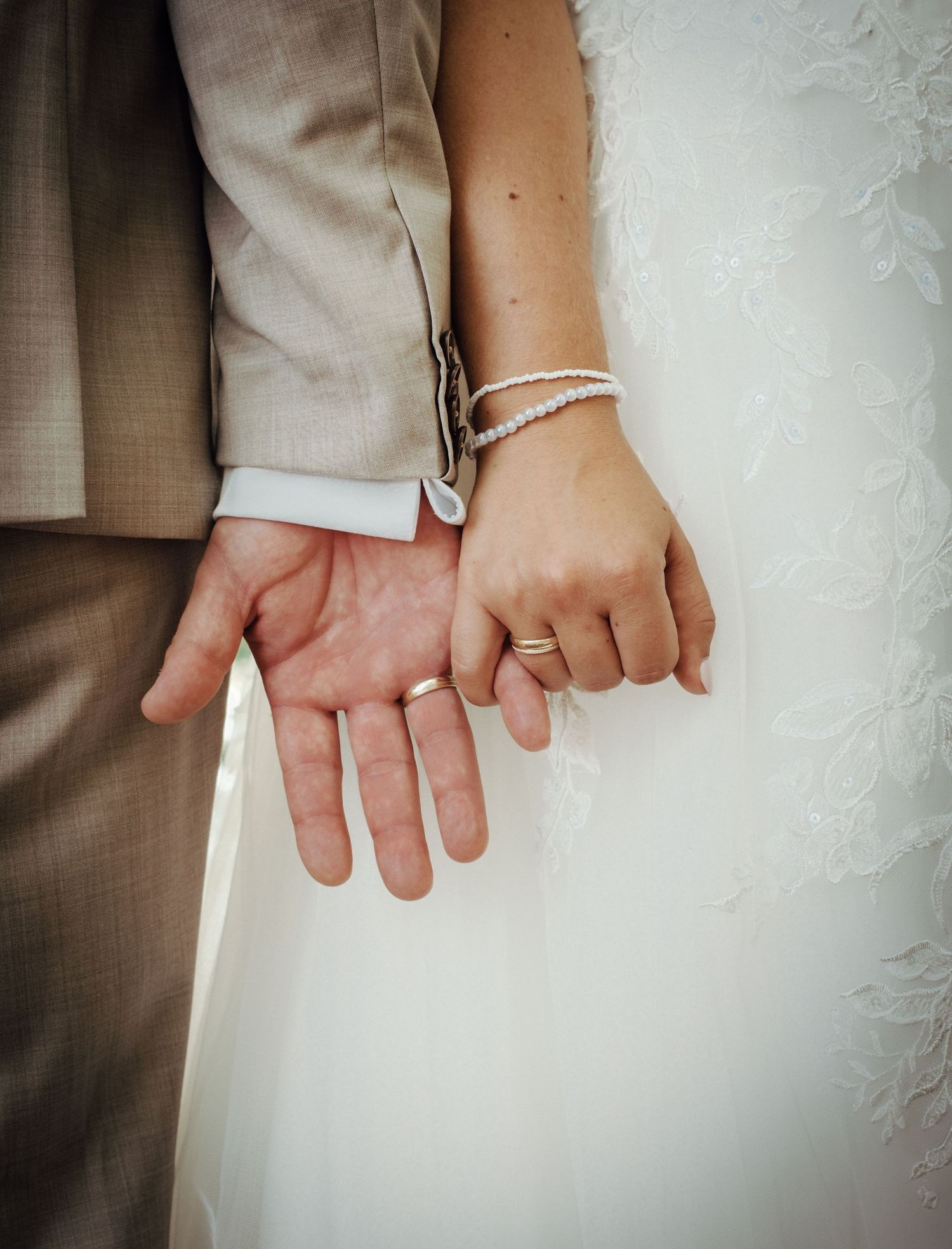 Close-up series of hands with wedding rings showing tender moments between newlyweds.