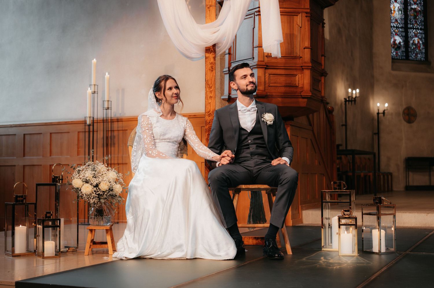 Romantic wedding couple shares intimate moments in an elegant church venue with warm lighting and vintage decor.