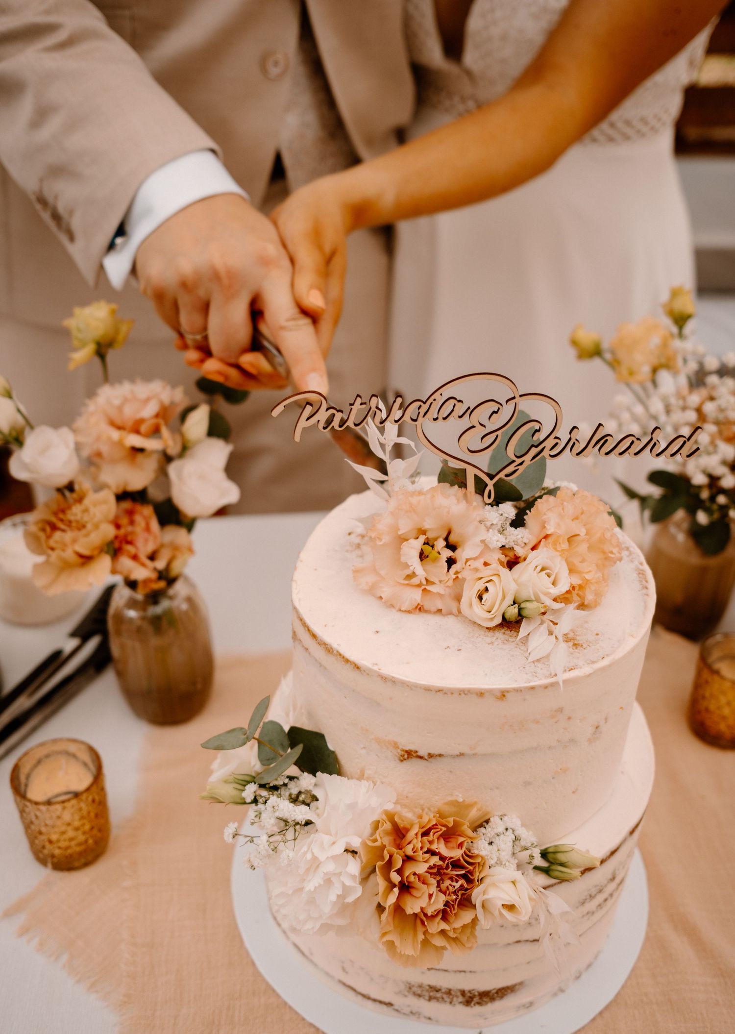 A sequence of images showing hands decorating a delicate pink wedding cake with fresh flowers and floral arrangements.