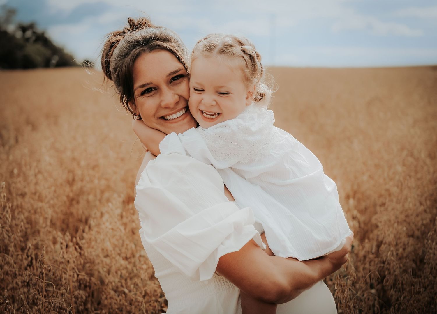 A heartwarming series of candid moments between parent and child in a golden wheat field at sunset.