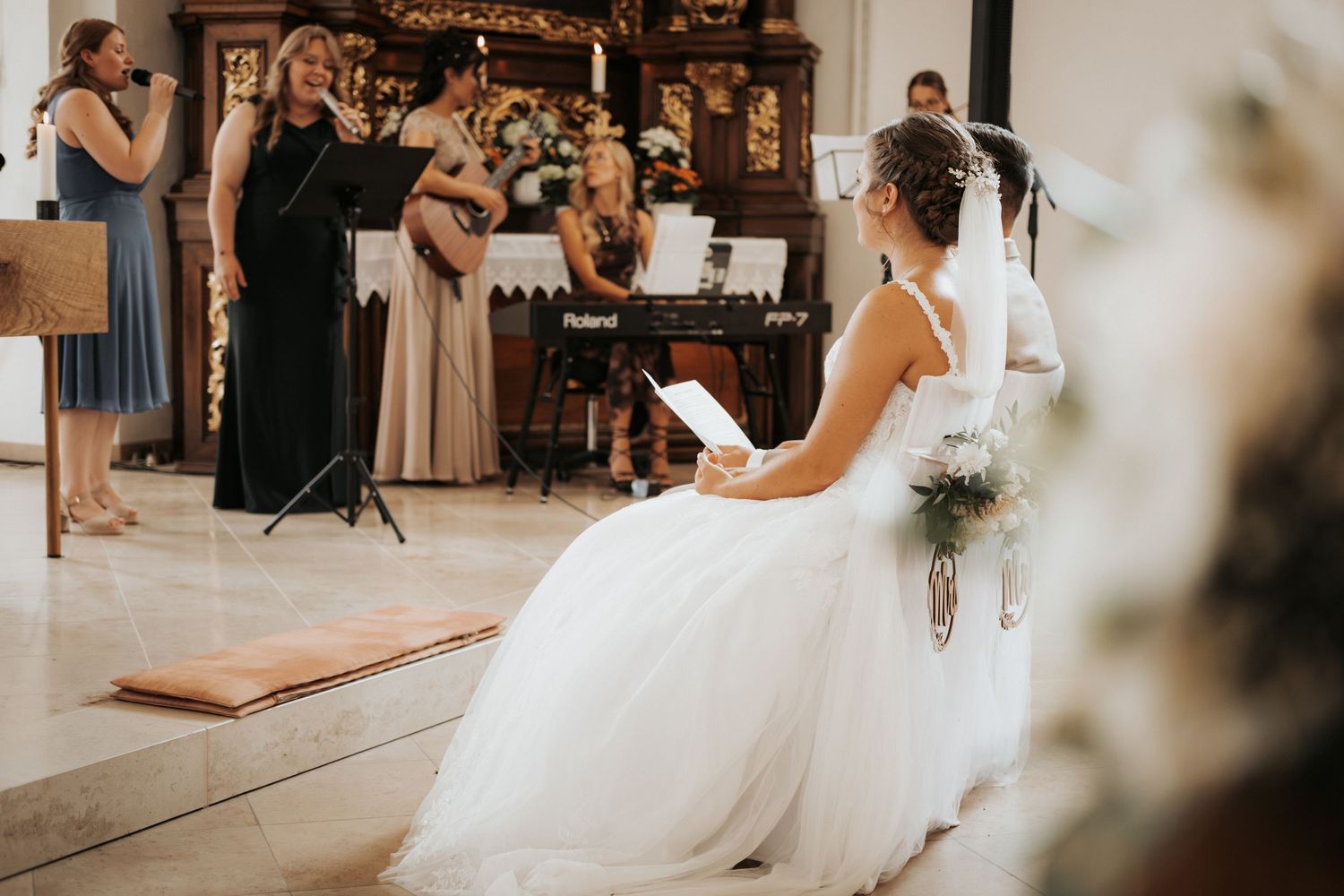 A bride in a flowing white gown twirls gracefully on a wooden dance floor during a wedding reception.