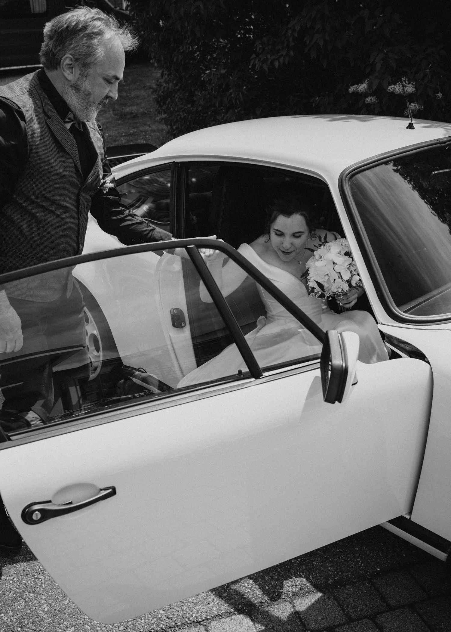 Sequential shots of people entering and getting situated in a classic white vintage car.