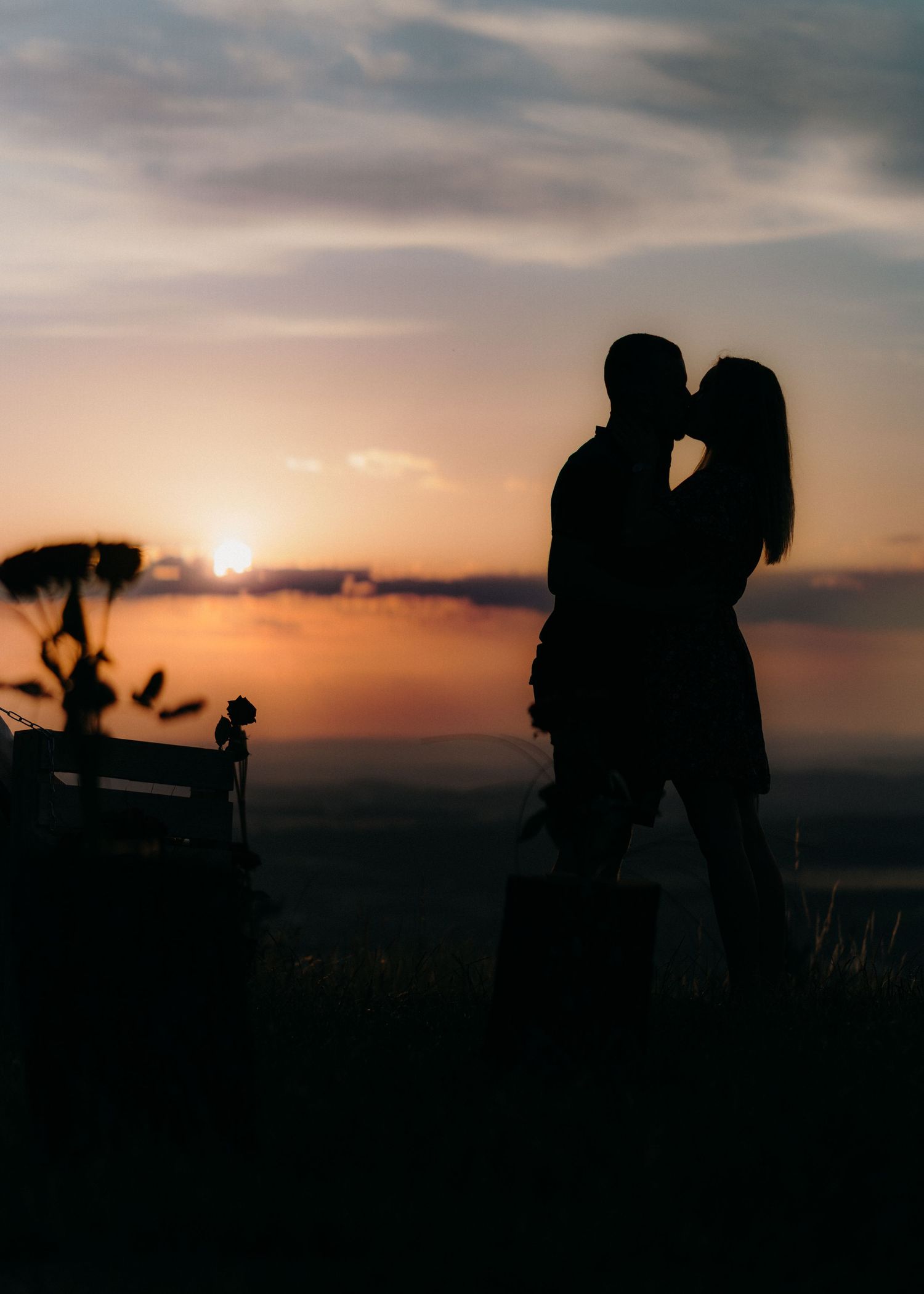 Silhouettes of couples sharing romantic moments against a dramatic sunset sky in a series of connected photos.