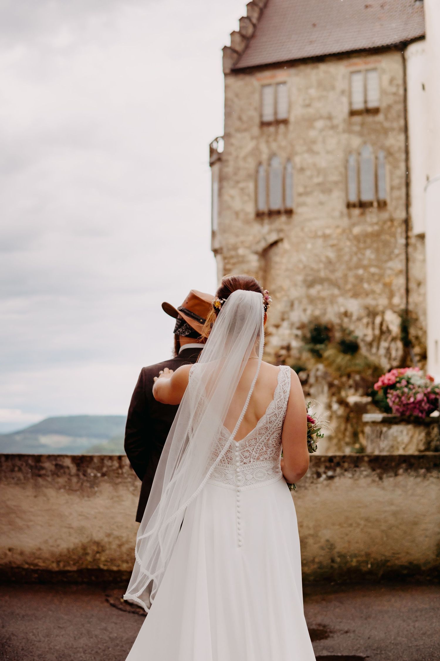 A romantic wedding photoshoot sequence showing a couple in formal attire against a historic stone castle backdrop.