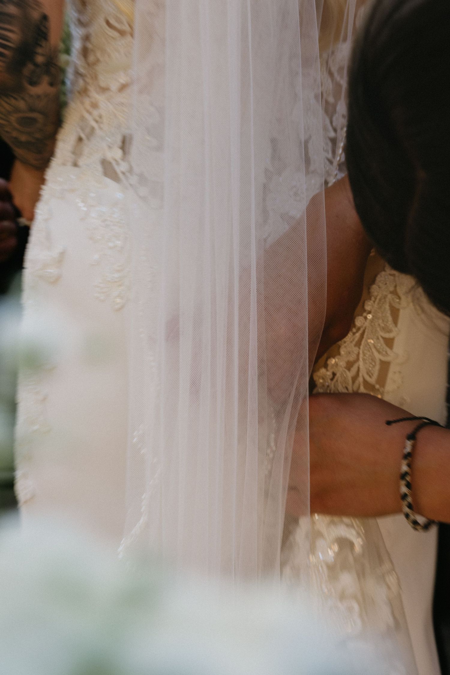 Close-up details of delicate white lace and tulle from a wedding dress.
