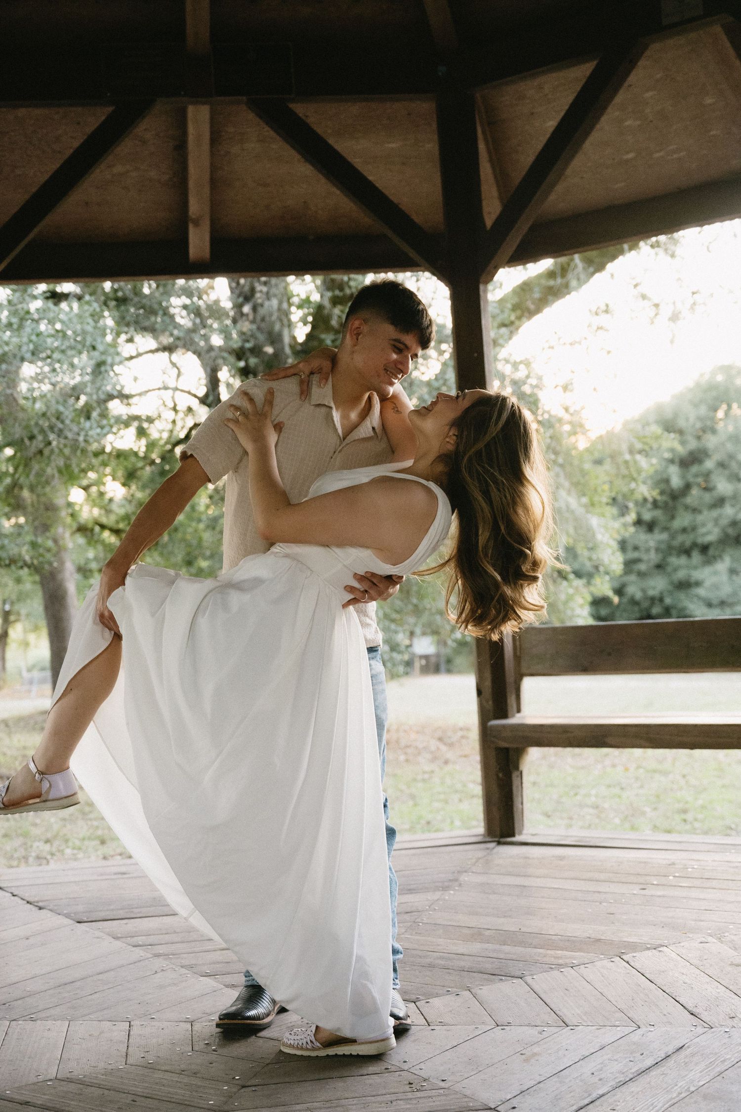 A romantic dance sequence on a wooden deck in casual attire.
