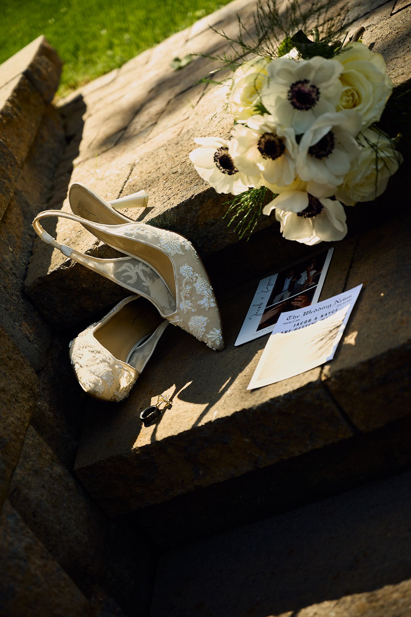 White floral wedding decorations and details arranged on a rustic stone surface.