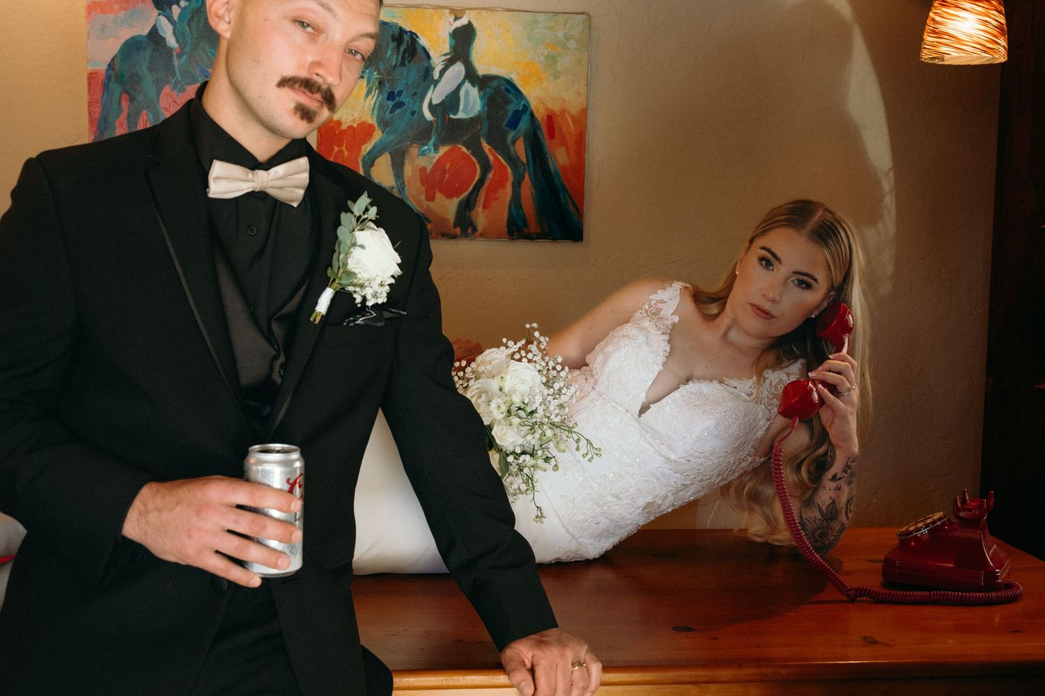 Wedding reception scene with warm lighting and decorative artwork on wall.