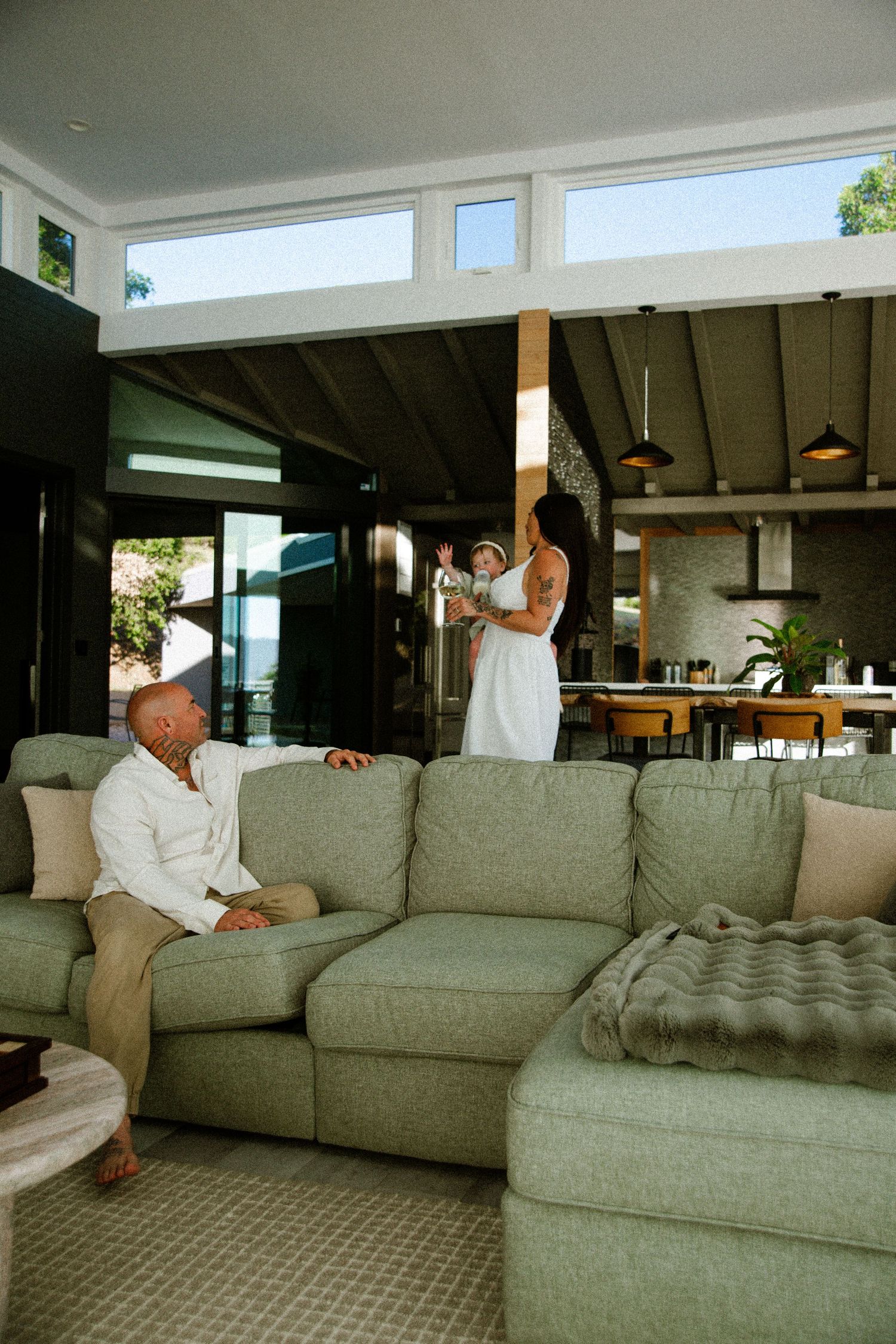Contemporary living space featuring a large grey sectional couch and pendant lighting.