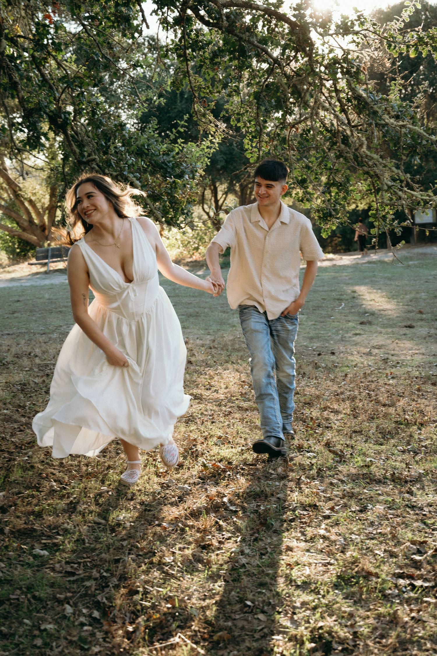 Playful wedding photo sequence showing couple running through fallen autumn leaves.