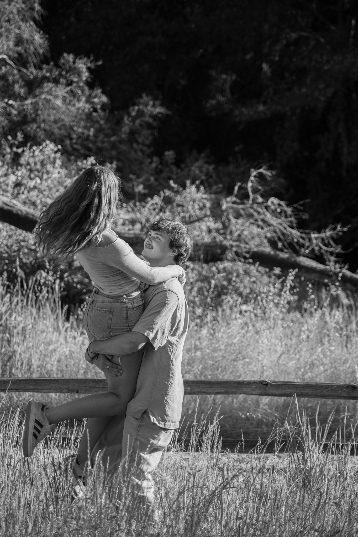 A tender black and white portrait captured in a natural outdoor setting.
