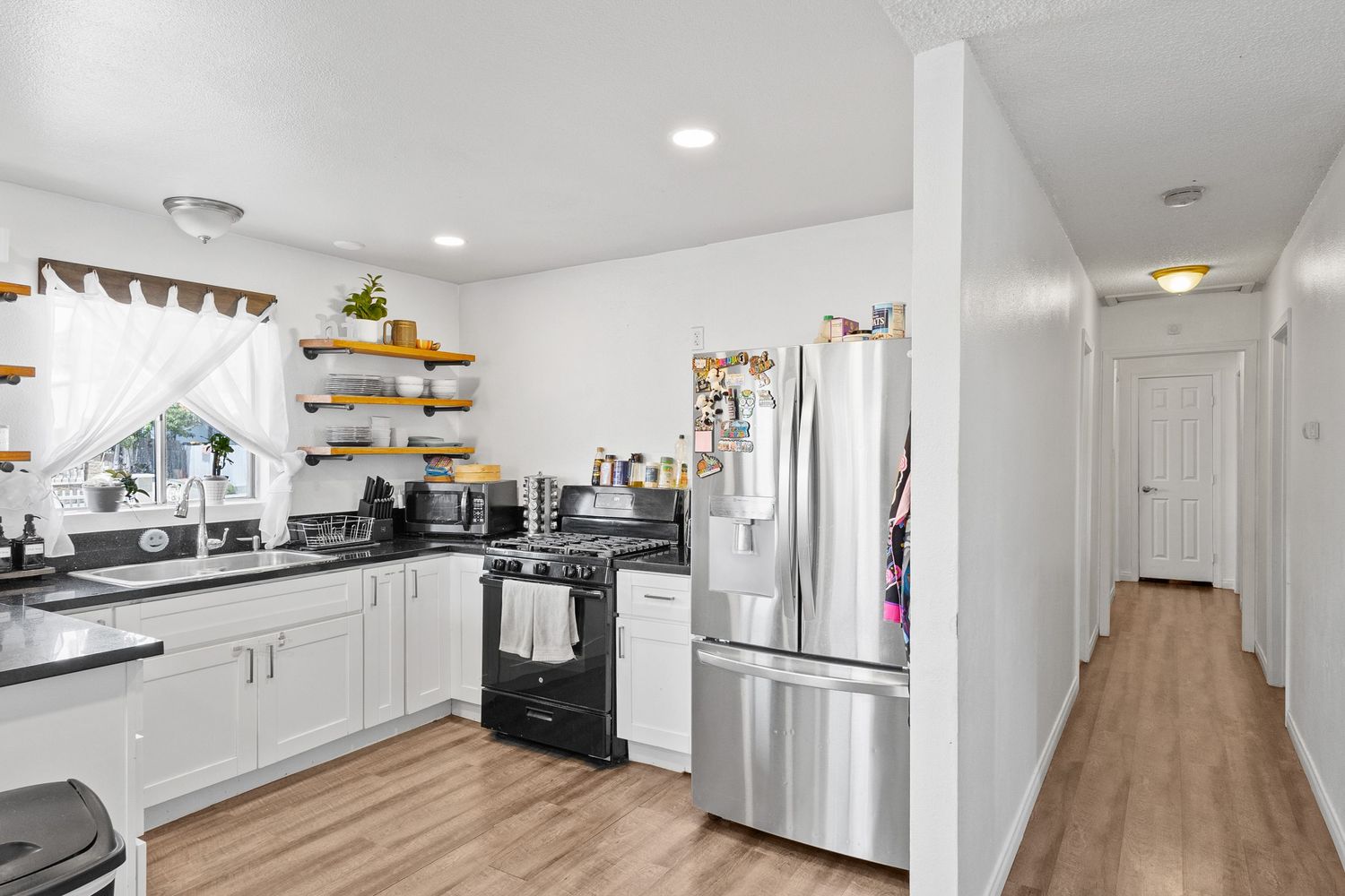 Open concept living space with vinyl flooring and recessed lighting throughout.