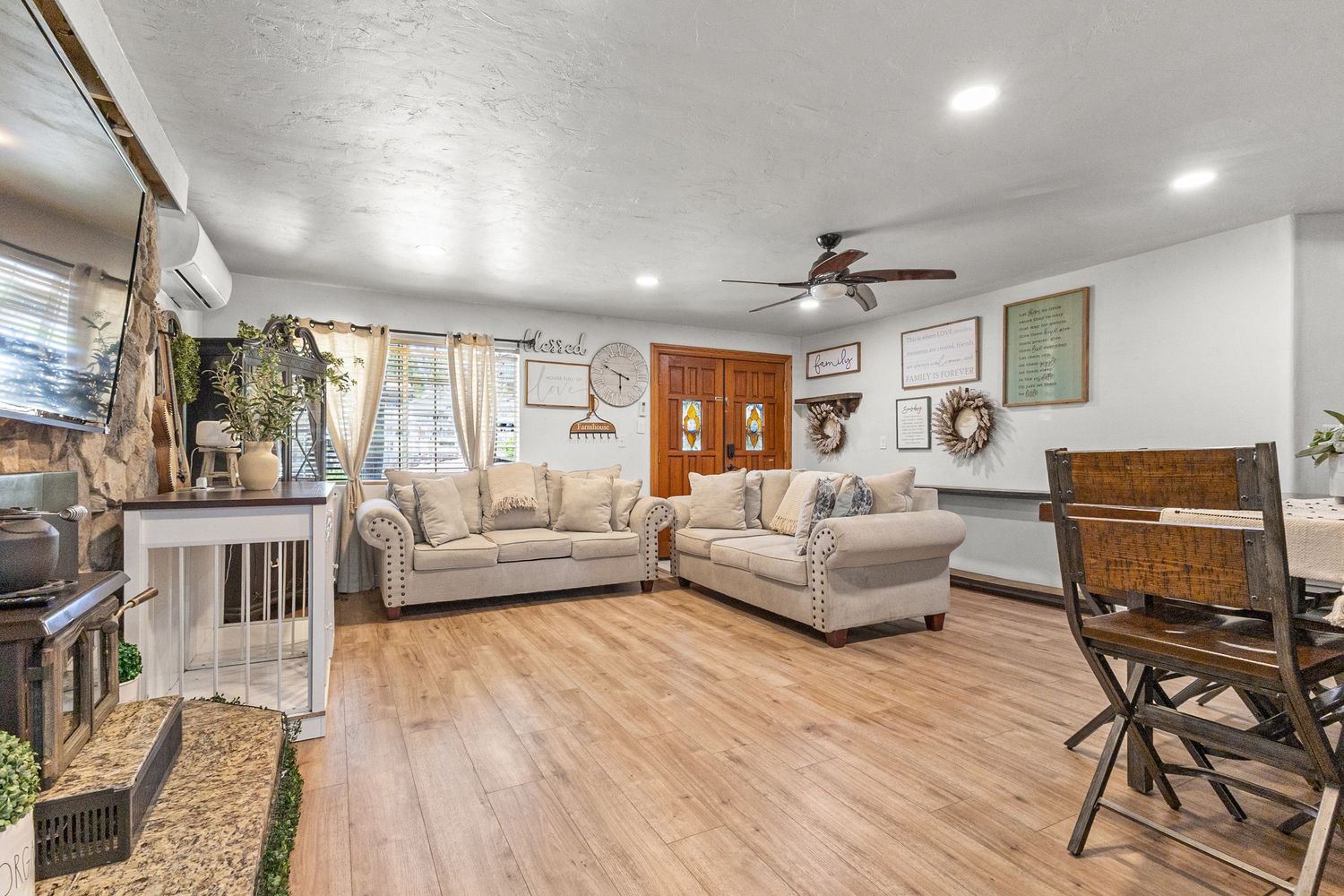 Modern open concept living room with light wood flooring and recessed lighting.