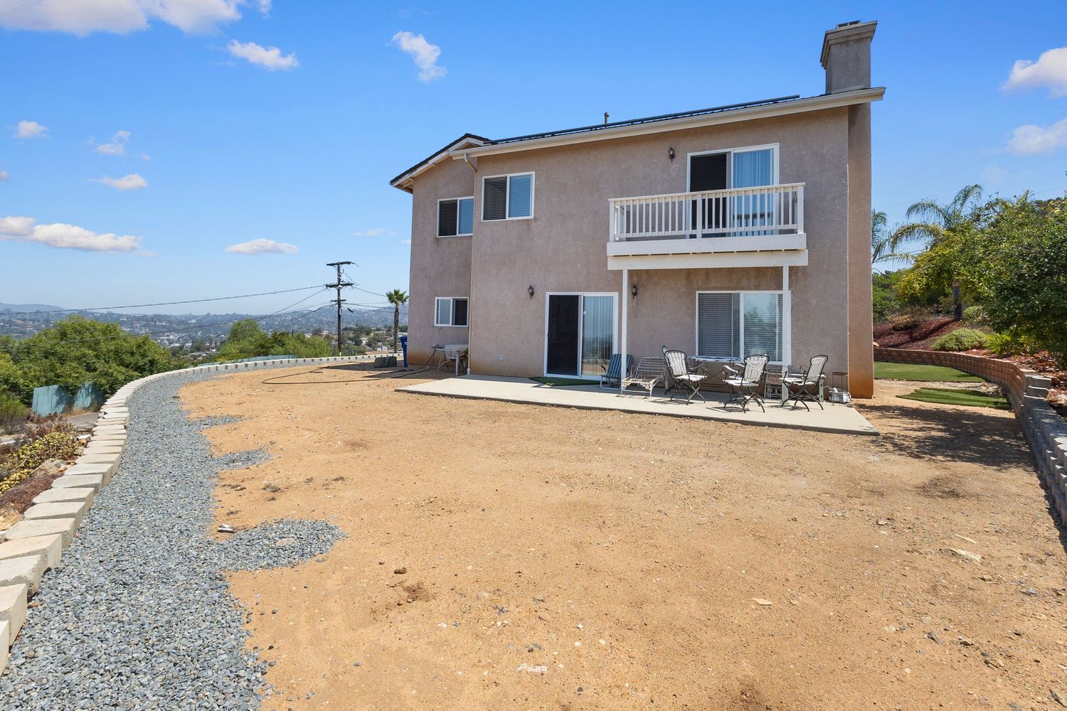 Wide angle exterior view of residential property with dirt landscape area.