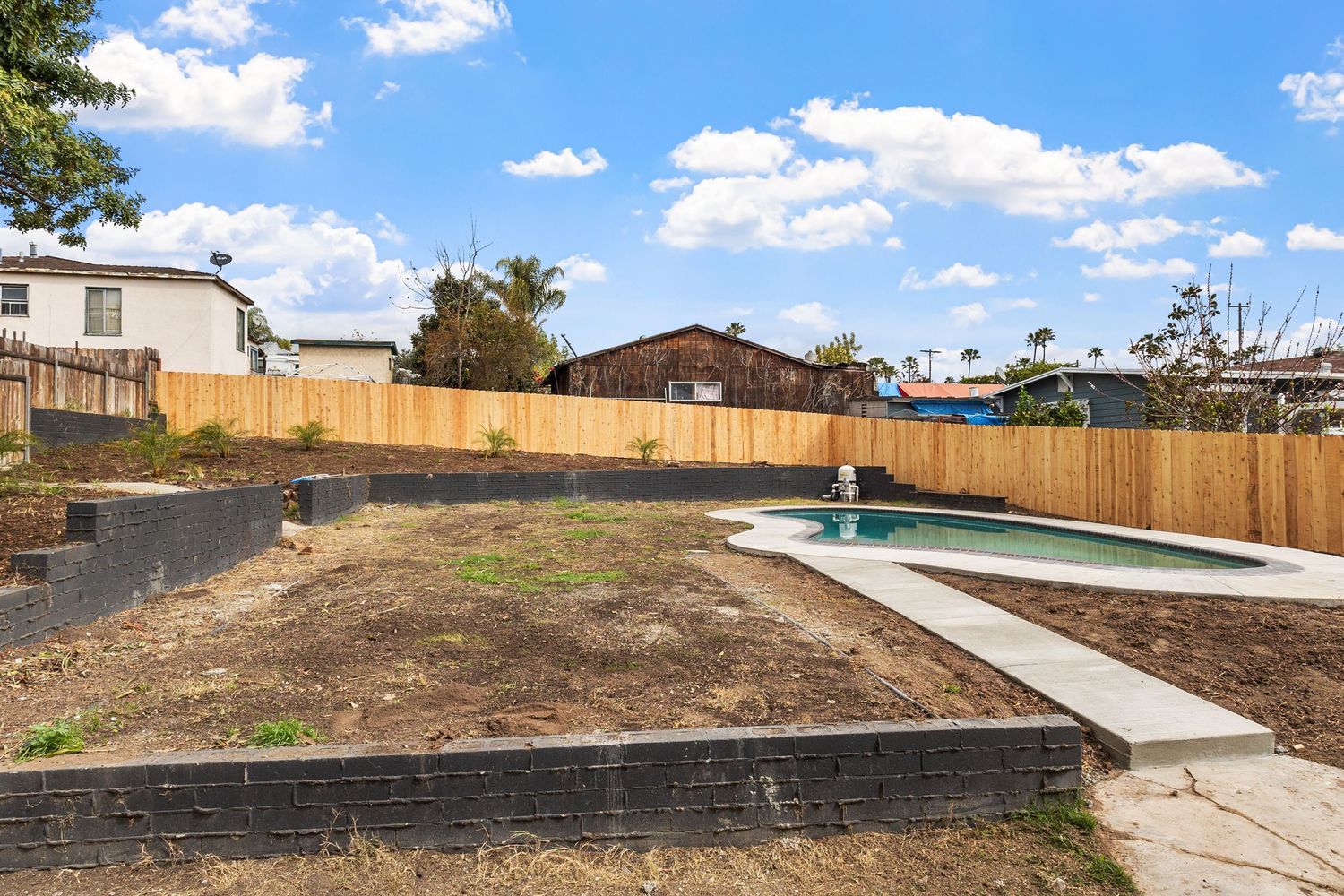 Panoramic aerial view of suburban backyard spaces with swimming pool visible.