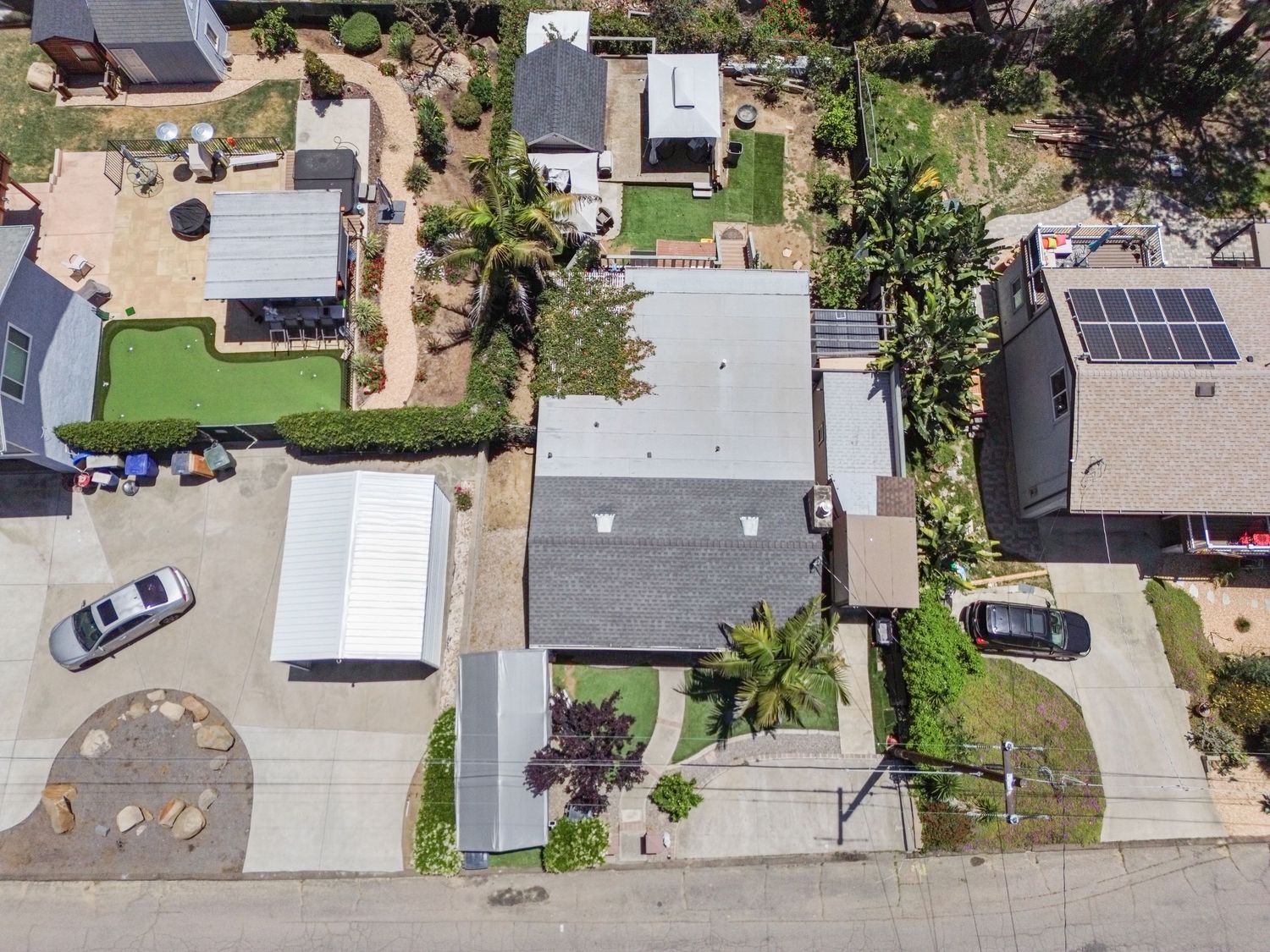 Bird's eye view of residential street showing multiple homes and landscaped yards.
