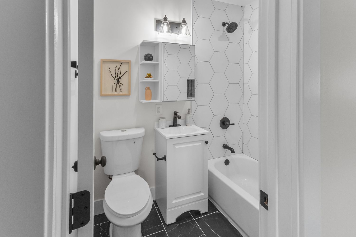 Clean white bathroom with hexagonal tile floors and modern fixtures.