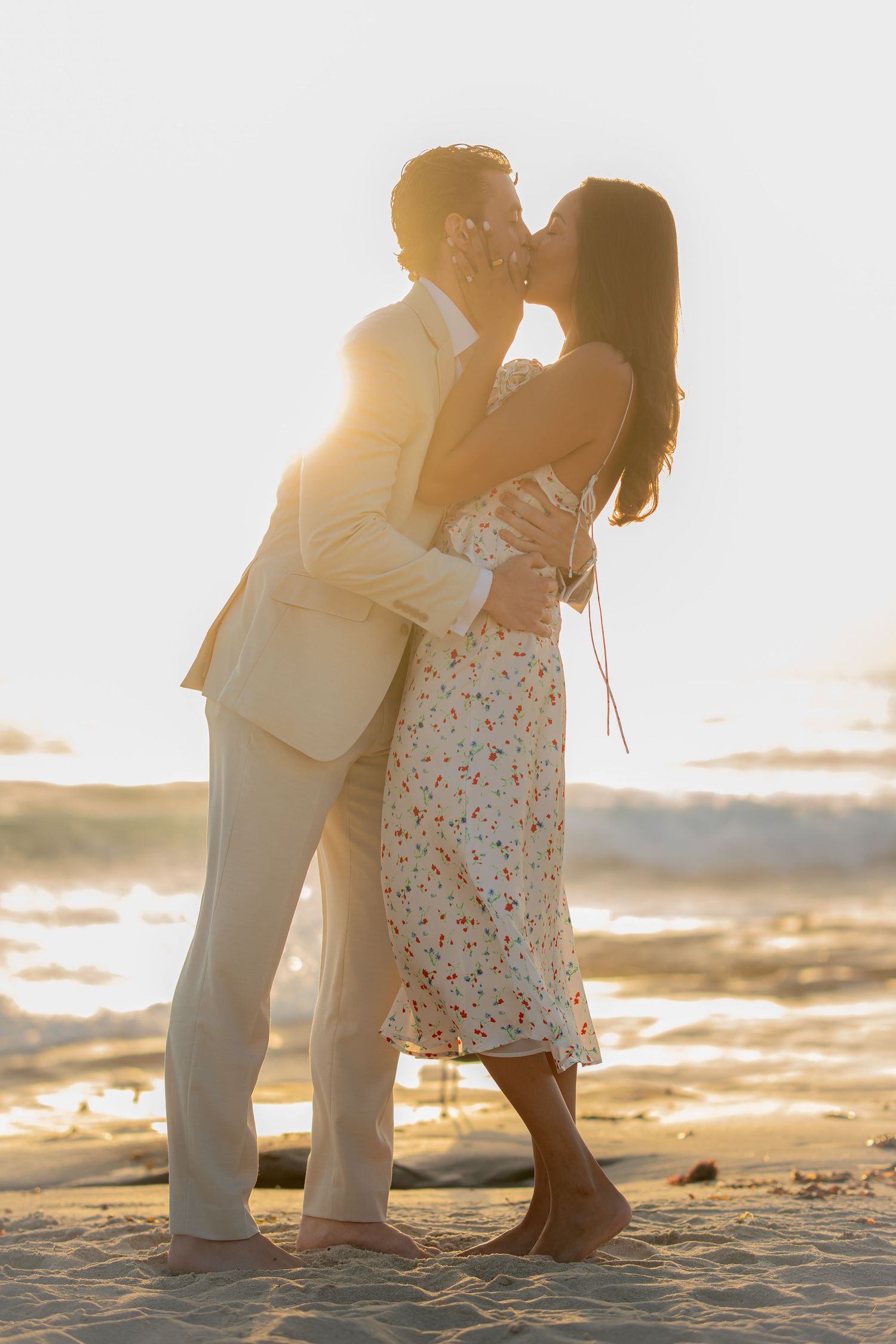 Silhouetted couple shares romantic moment on beach at golden hour.