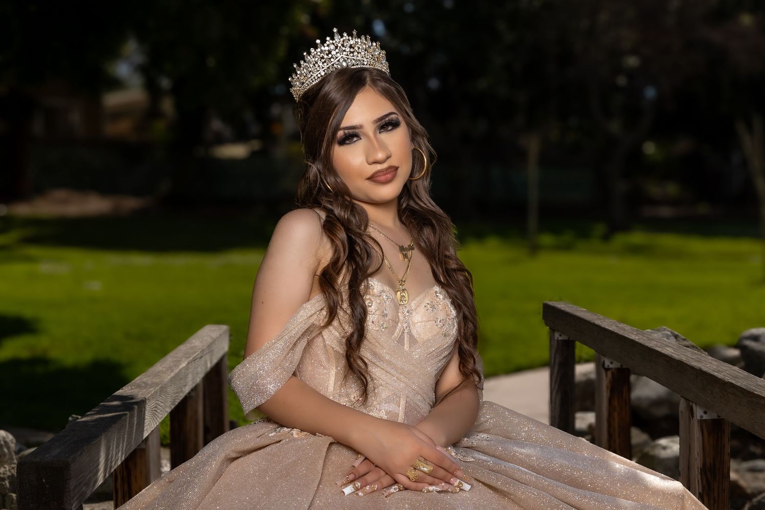A dreamy outdoor portrait in a champagne-colored ball gown on a wooden bridge.