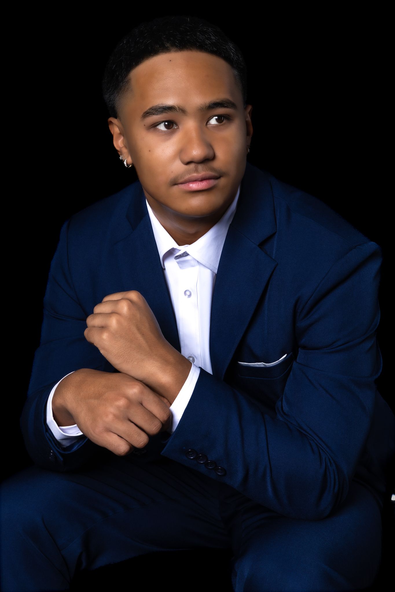 Professional portrait series showing a person in a navy suit and white shirt against a dark background.
