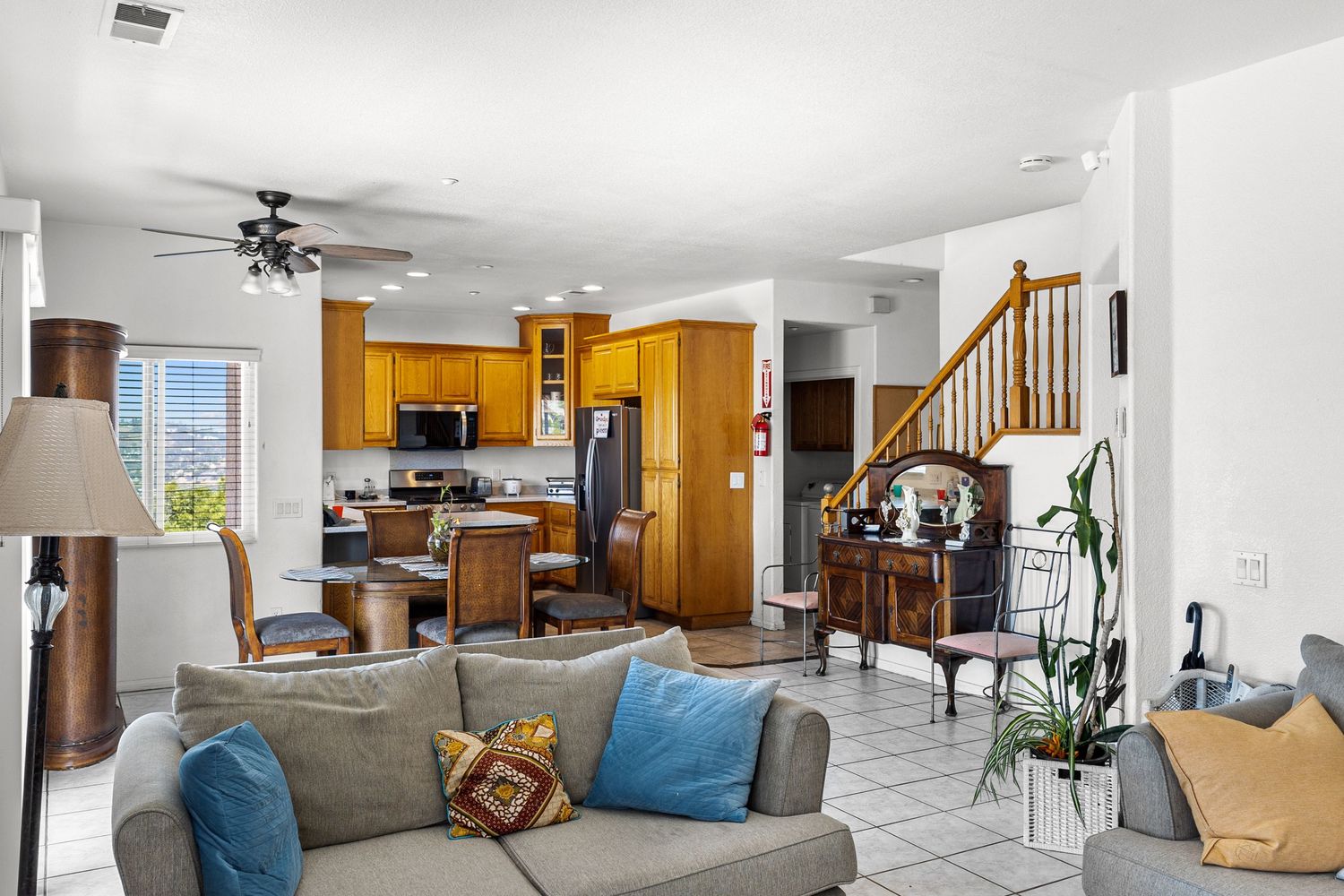 Spacious living area with vaulted ceiling featuring grey furniture and warm wood tones.