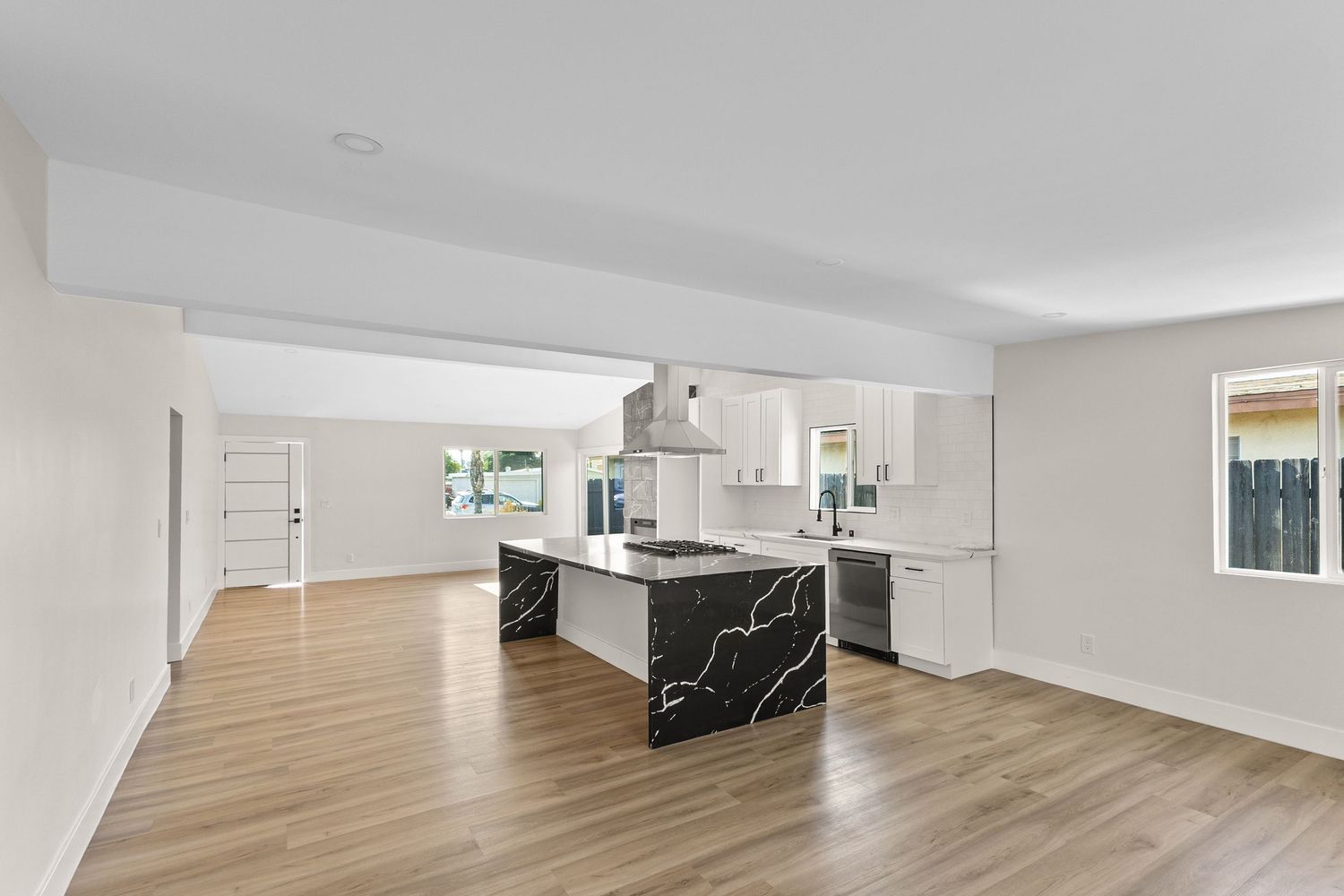 Open concept living space with light wood flooring and white walls.