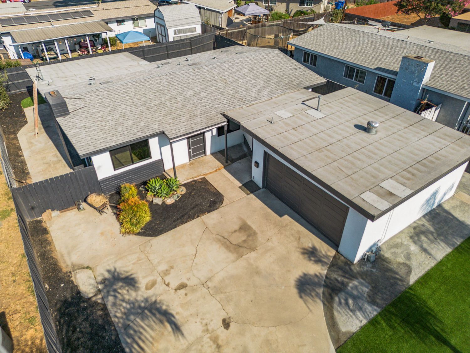 Aerial view of a modern residential property with white exterior and attached garage.