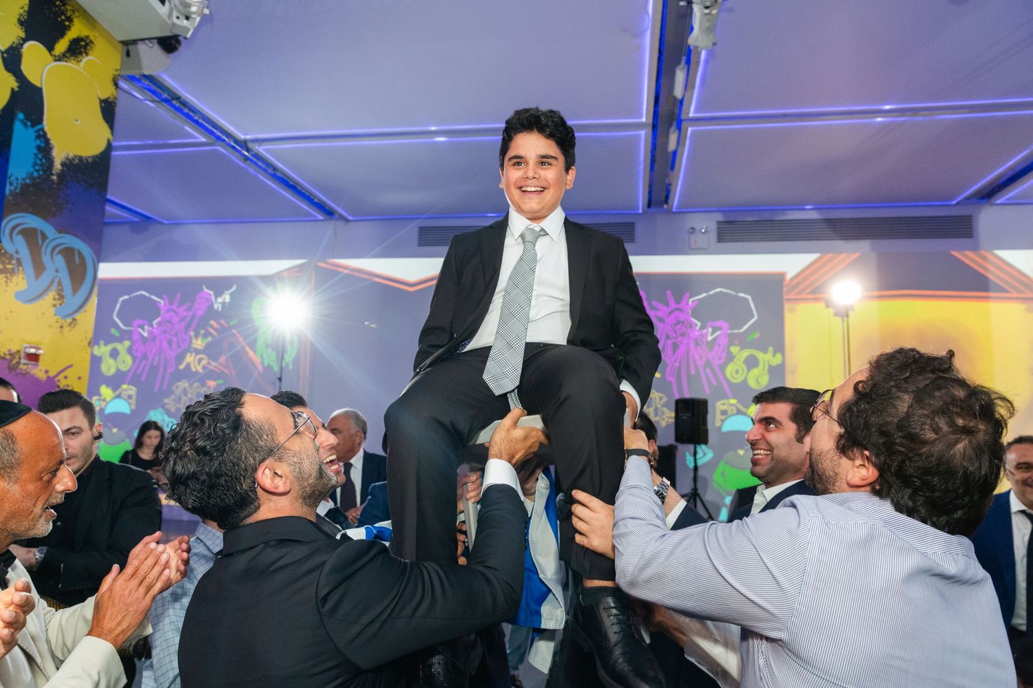 Celebration event with blue lighting and guests dancing in formal attire.