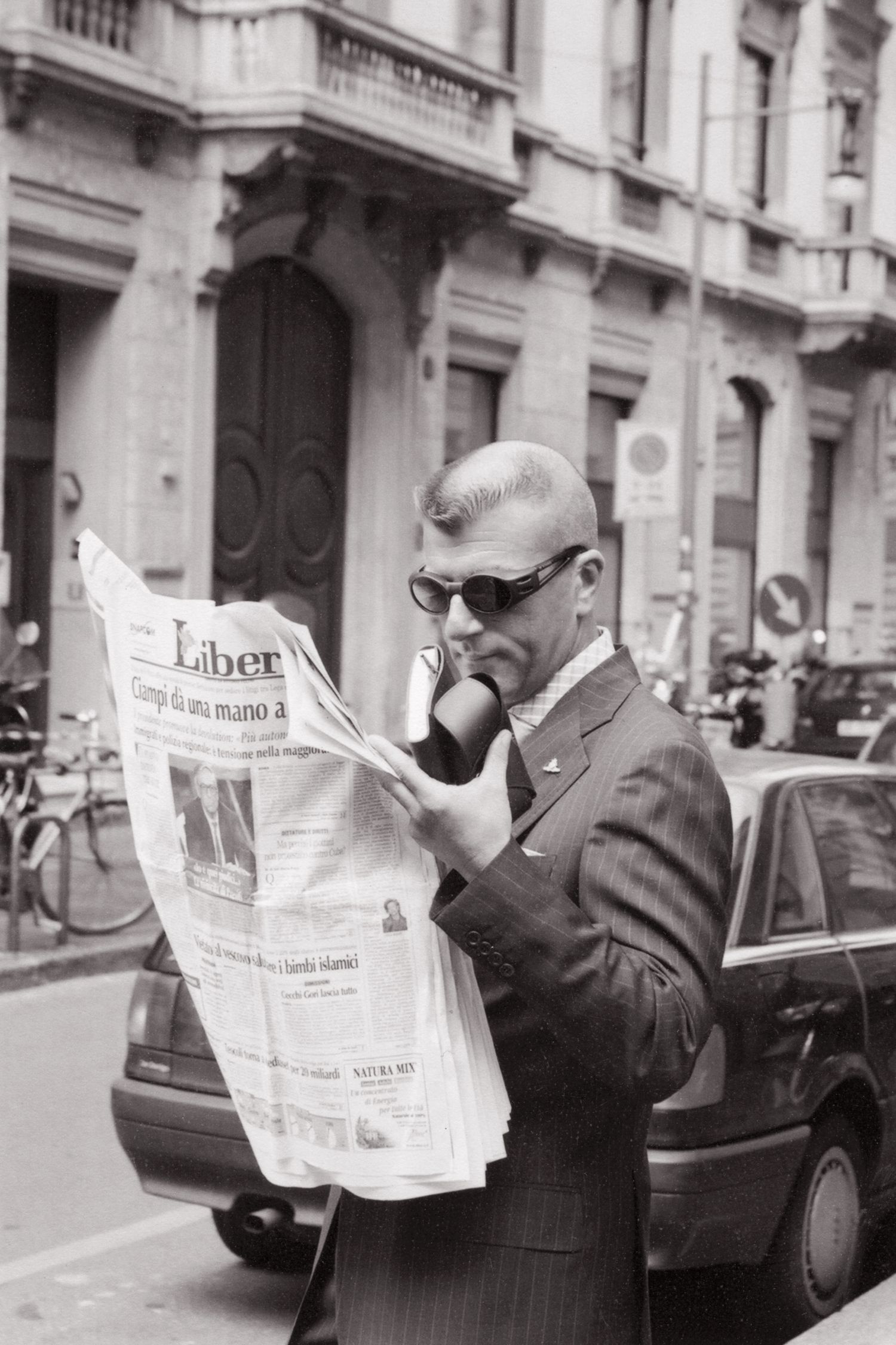 Four vintage black and white photos showing people reading newspapers on a city street.