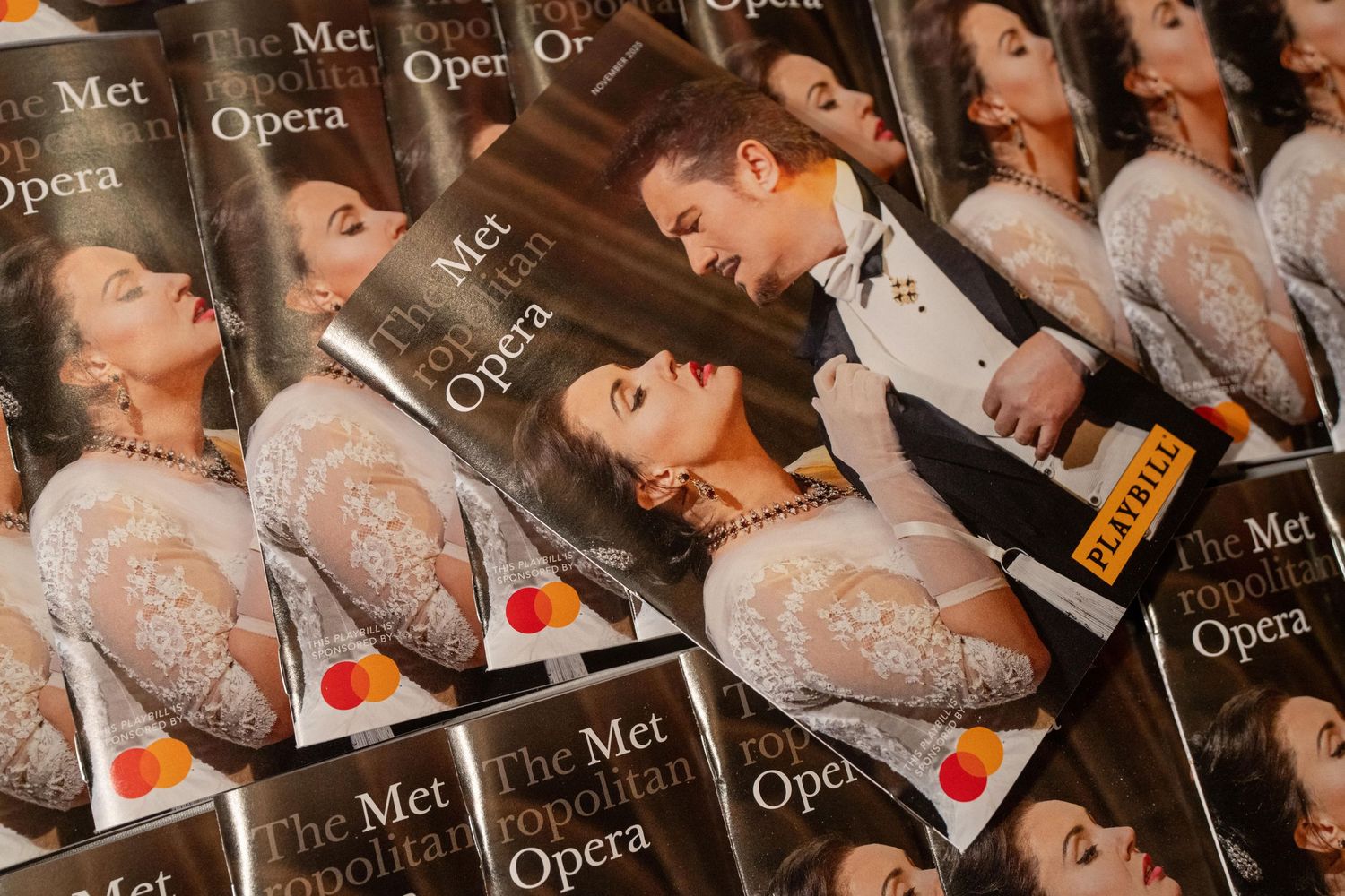 Multiple Metropolitan Opera programs fanned out, featuring elegantly dressed performers on the glossy covers.