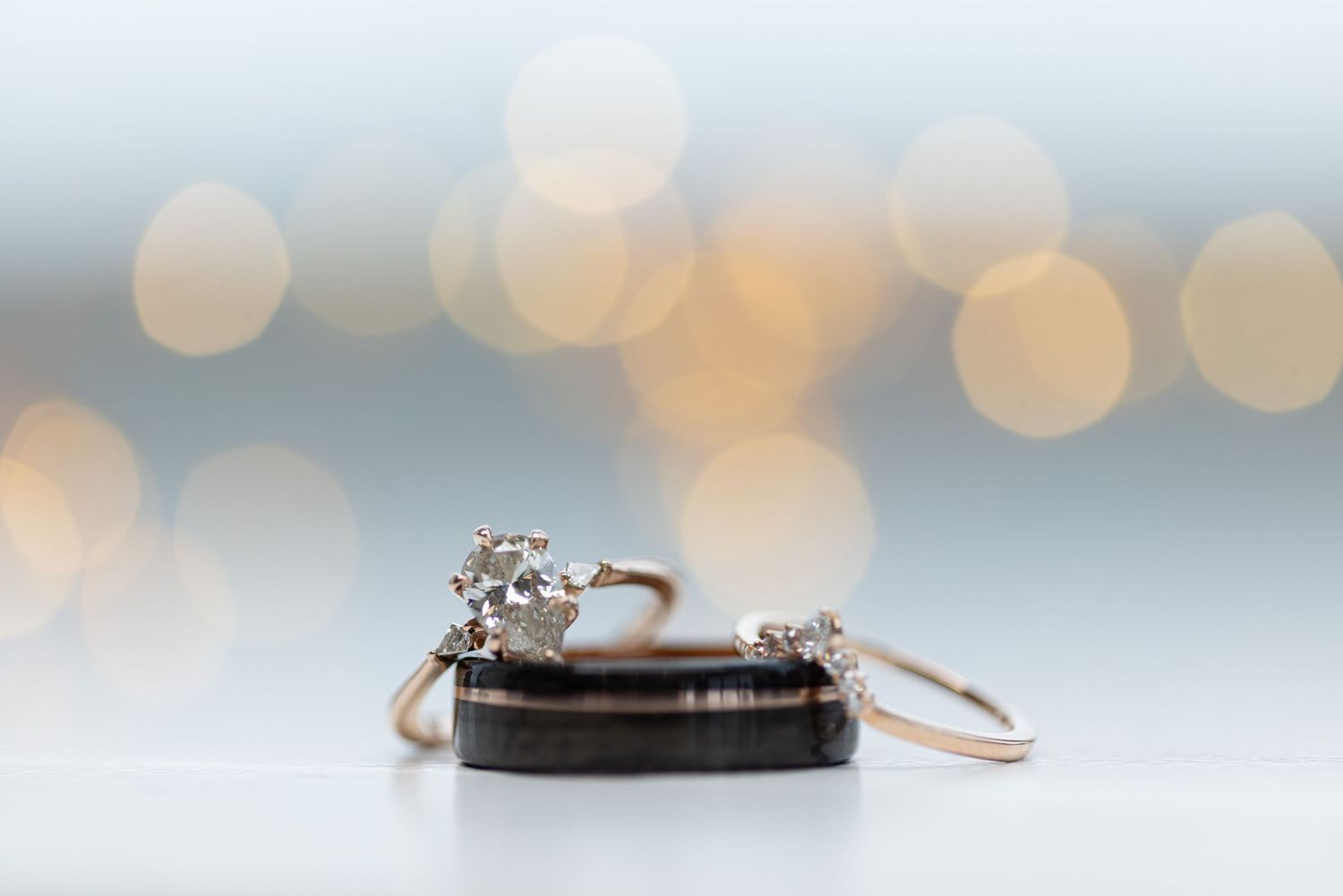 Wedding rings photographed with bokeh lights in background.