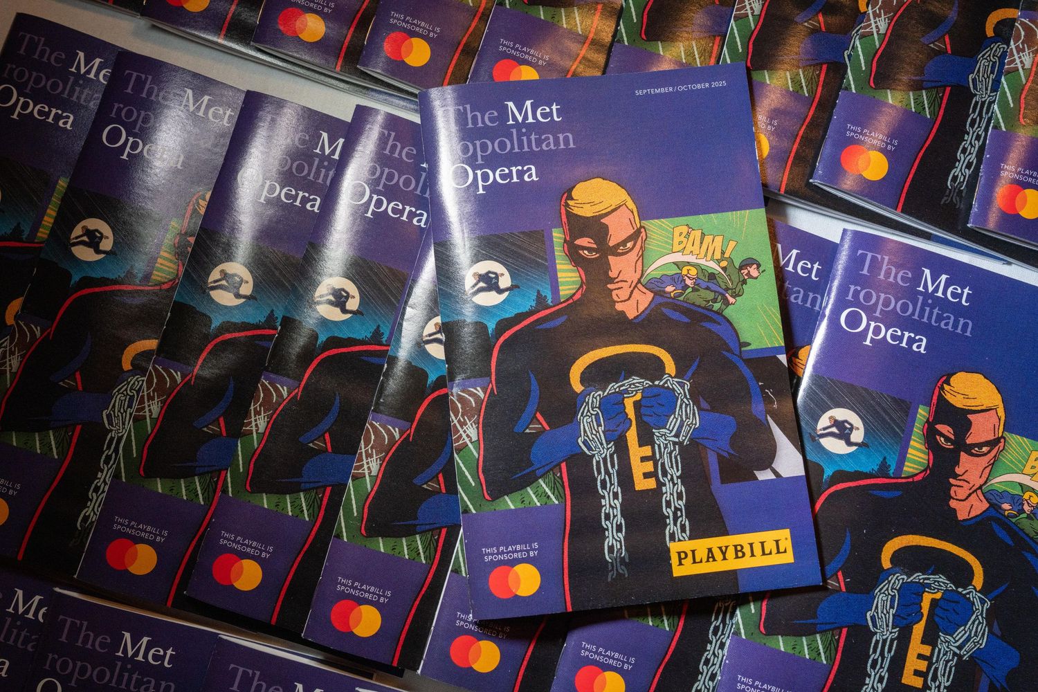 Metropolitan Opera Playbill programs with Mastercard branding fanned out on display at venue.