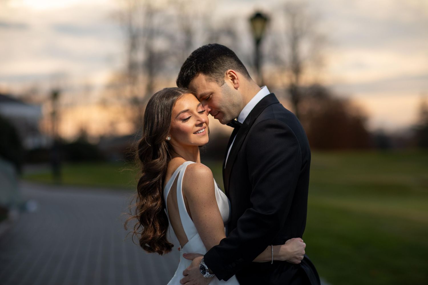 Romantic sunset wedding portraits with soft golden light and natural outdoor backdrop.
