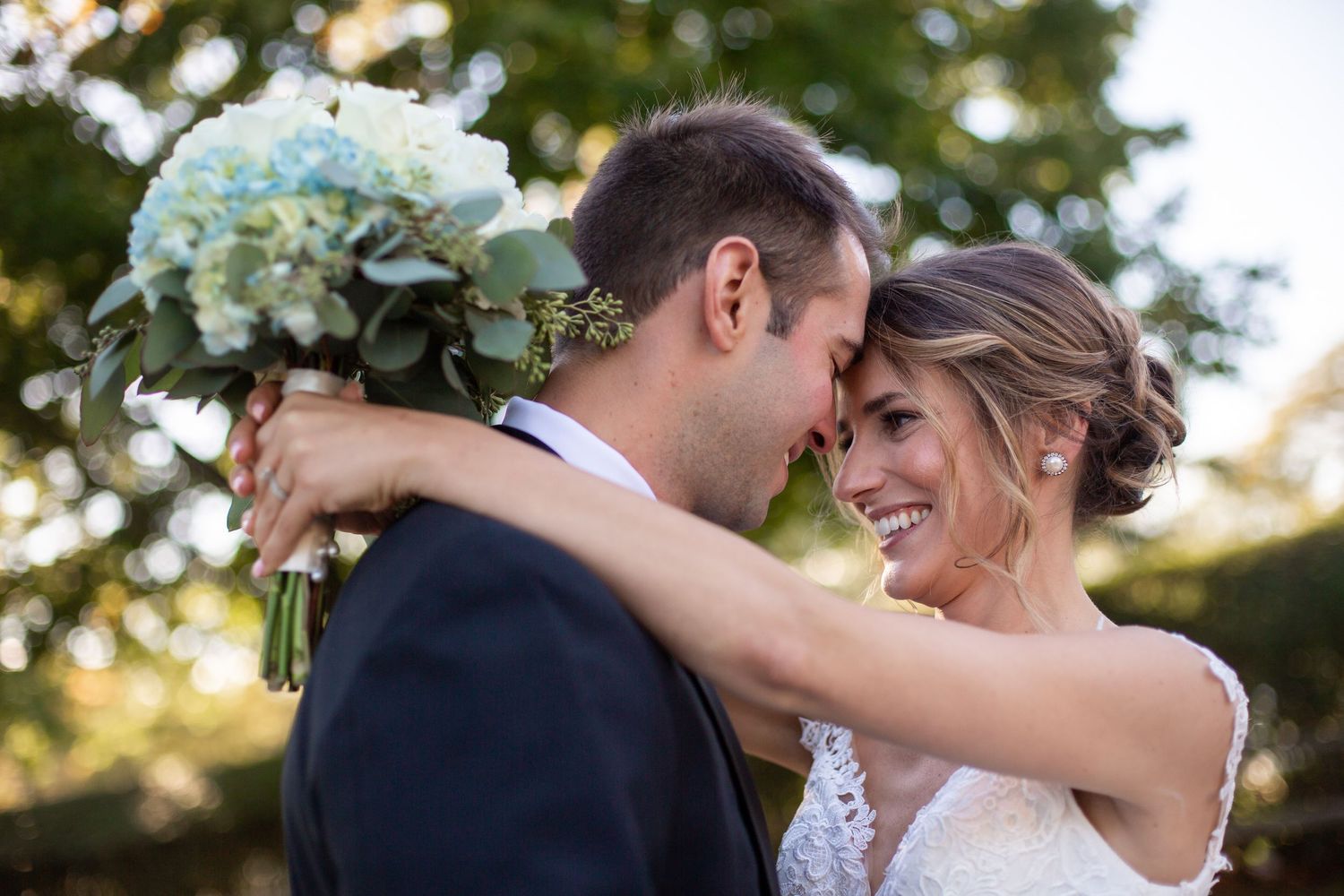 Romantic outdoor wedding portraits showing tender embraces between newlyweds.