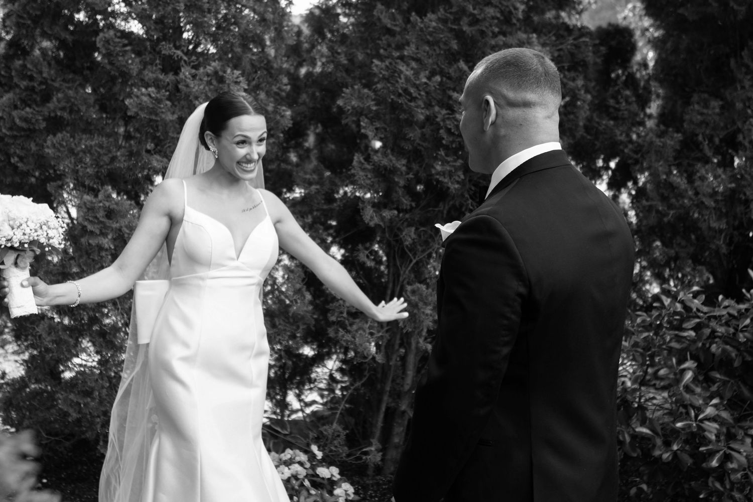 A black and white candid moment between a couple during their first look wedding reveal.