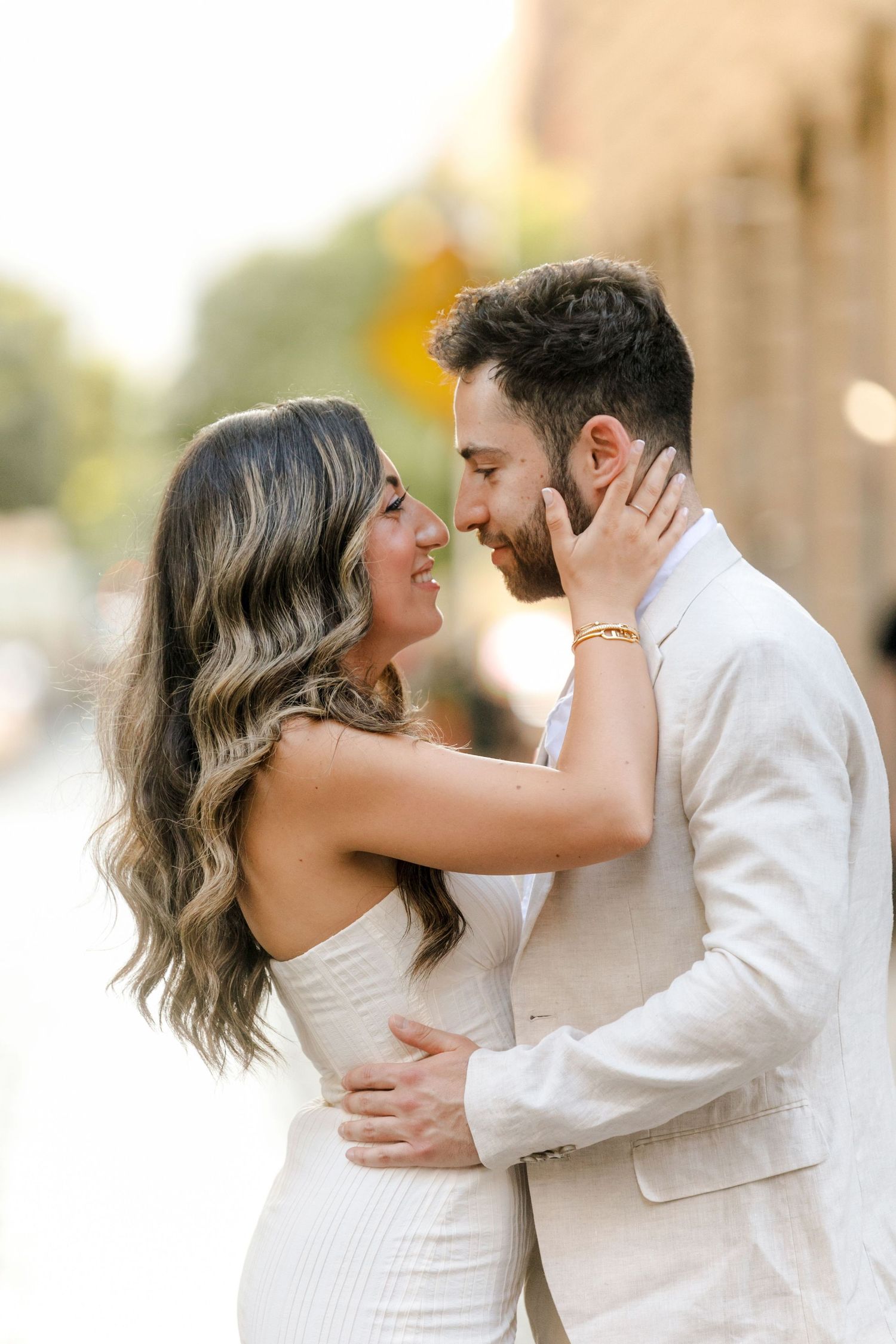 Intimate moment between a couple in formal attire sharing a laugh outdoors.